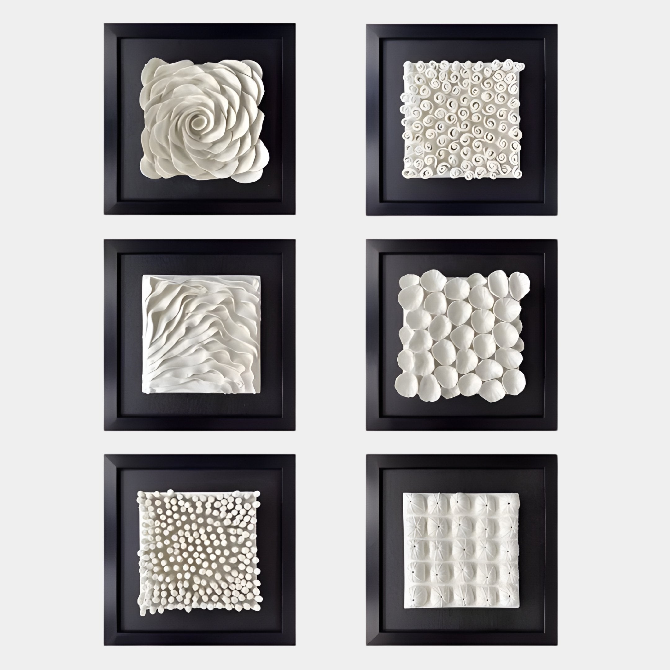 The Harmonia Set of 6 Ceramic 3D Wall Sculptures by Giant Sculptures features unique petal, wave, circle, and cluster patterns in black frames—an elegant contemporary accent displayed in two columns.