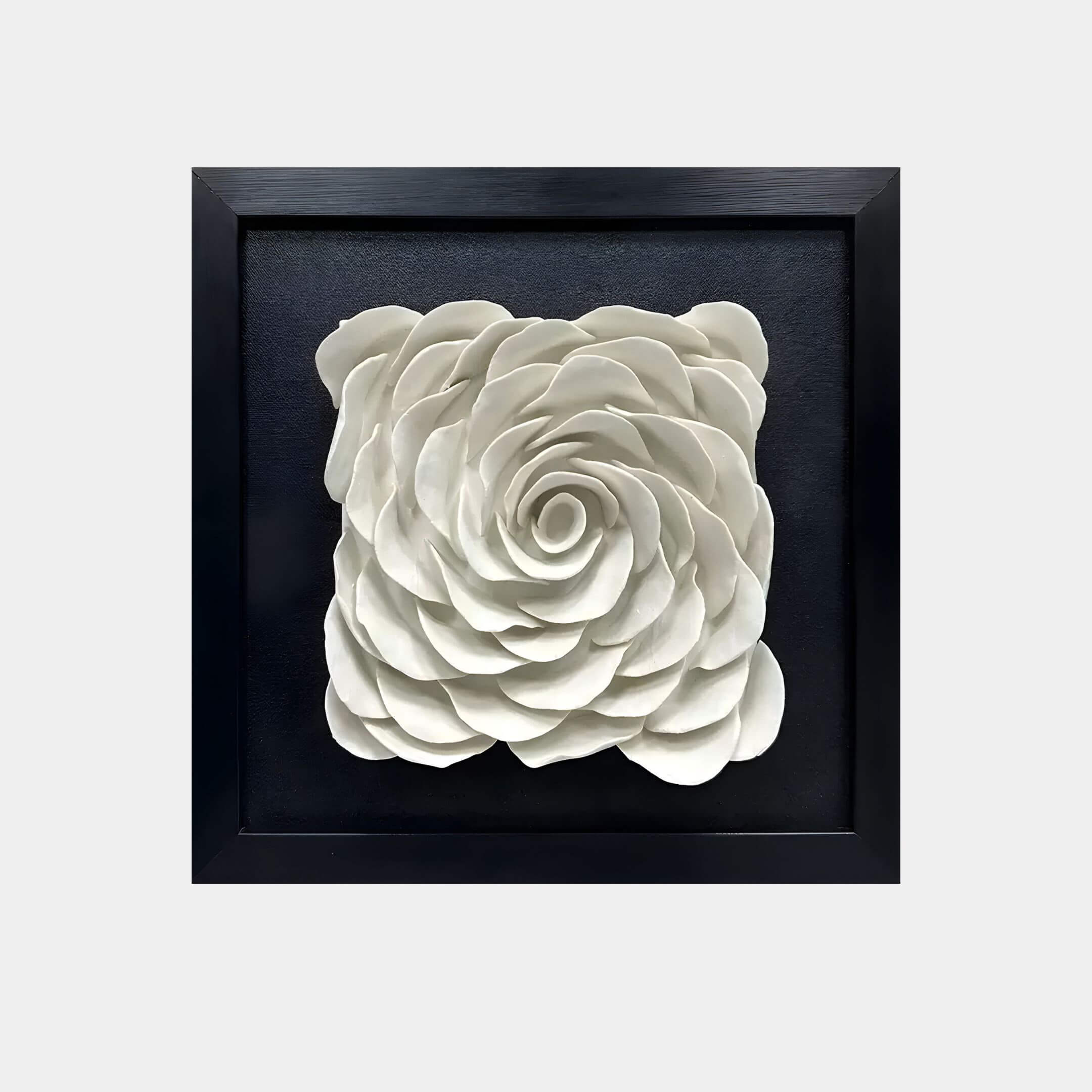 The Harmonia 3D Rose Wall Installation by Giant Sculptures is a ceramic wall sculpture with a spiral design of layered petals. It features a smooth white finish against a black background, framed elegantly in a sleek black square frame.