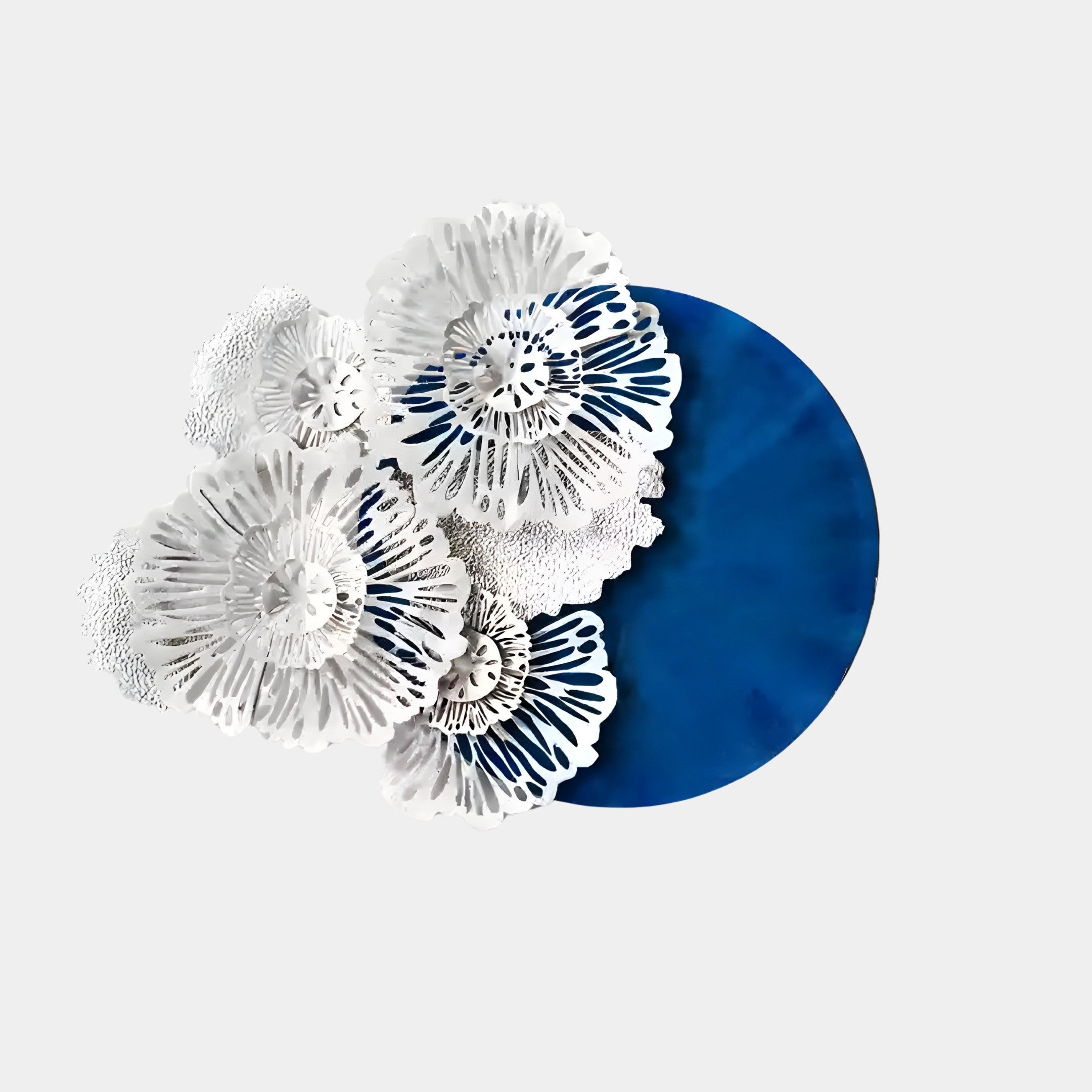 Aurum Flora White Petals by Giant Sculptures is a modern metal wall art piece with intricate white floral designs on a cobalt blue circle, set against light gray—ideal for contemporary spaces.