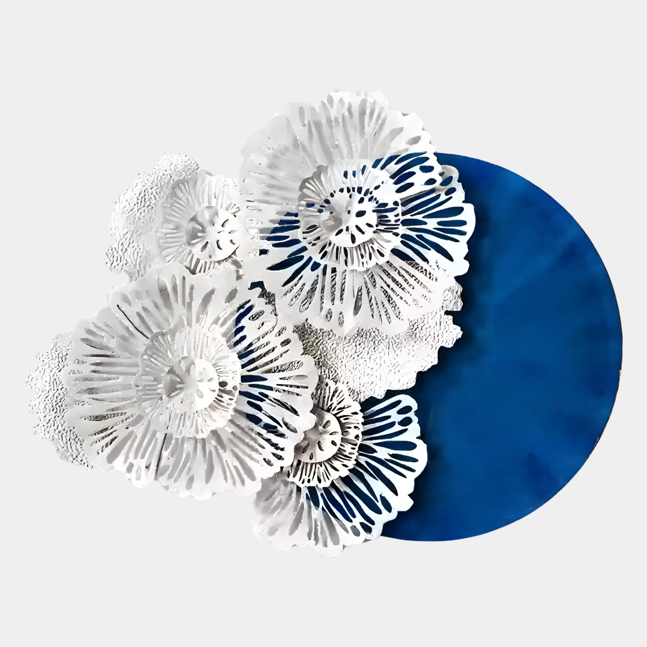 The Aurum Flora White Petals Cobalt Blue Metal Wall Art by Giant Sculptures features layered, floral-inspired white petals with intricate cut-outs set against a striking round cobalt blue backdrop for a bold 3D effect.