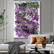 A contemporary living room features the Scriptura IV Multicolour Graffiti Expression Metal Wall Art by Giant Sculptures, with its bold black, purple, and green accents. The space is enhanced by modern interiors like a white sofa with patterned cushions, a glass coffee table, and stylish décor.