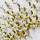 The Flock Golden Flight Sculpture by Giant Sculptures features small metallic bird-shaped sculptures forming a stunning 3D wall installation. Arranged on a white wall, these golden birds create an illusion of a flock in flight.