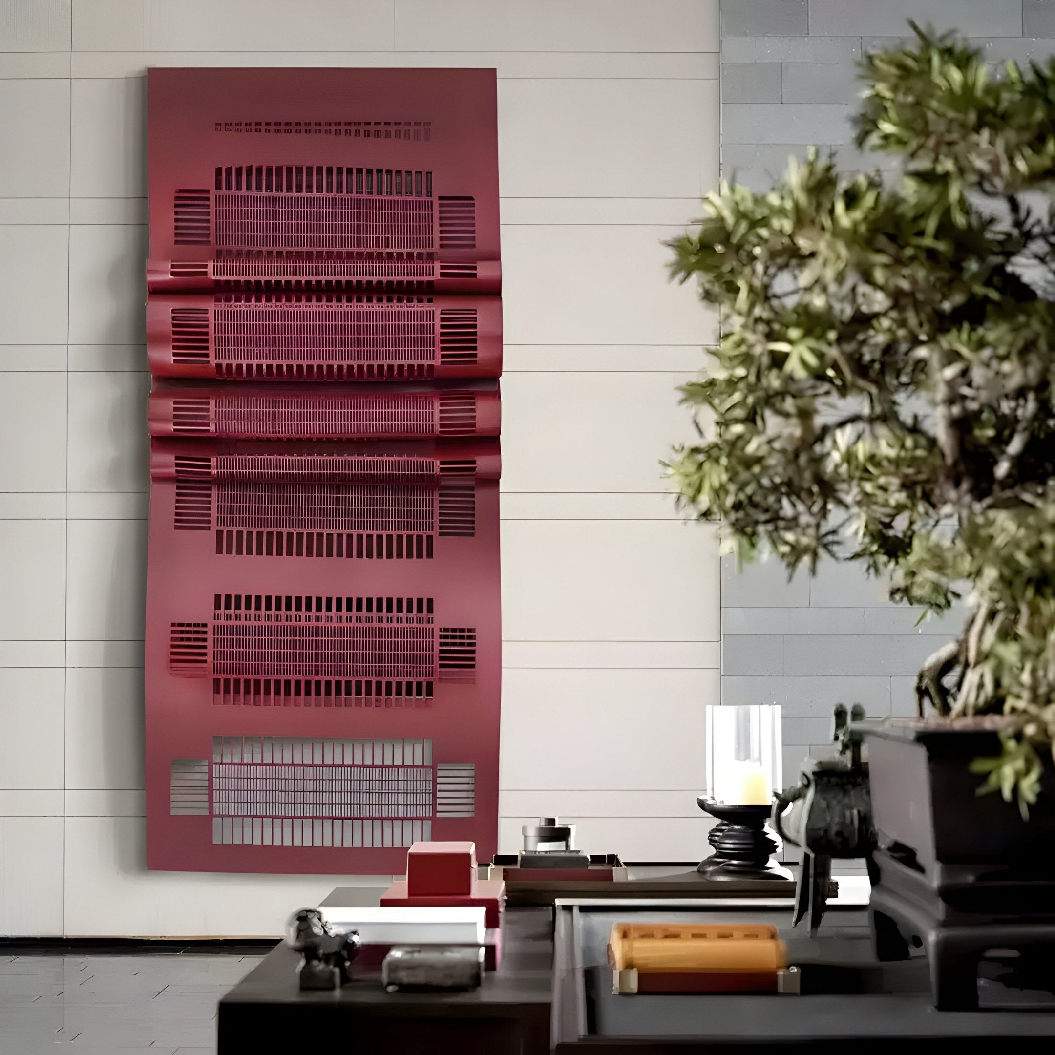 The modern interior highlights the Strata Red Vertical Folded Grid Metal Wall Art by Giant Sculptures. A table in the foreground showcases decorative items and a bonsai tree, skillfully merging contemporary and natural elements for a minimalist yet cohesive space.