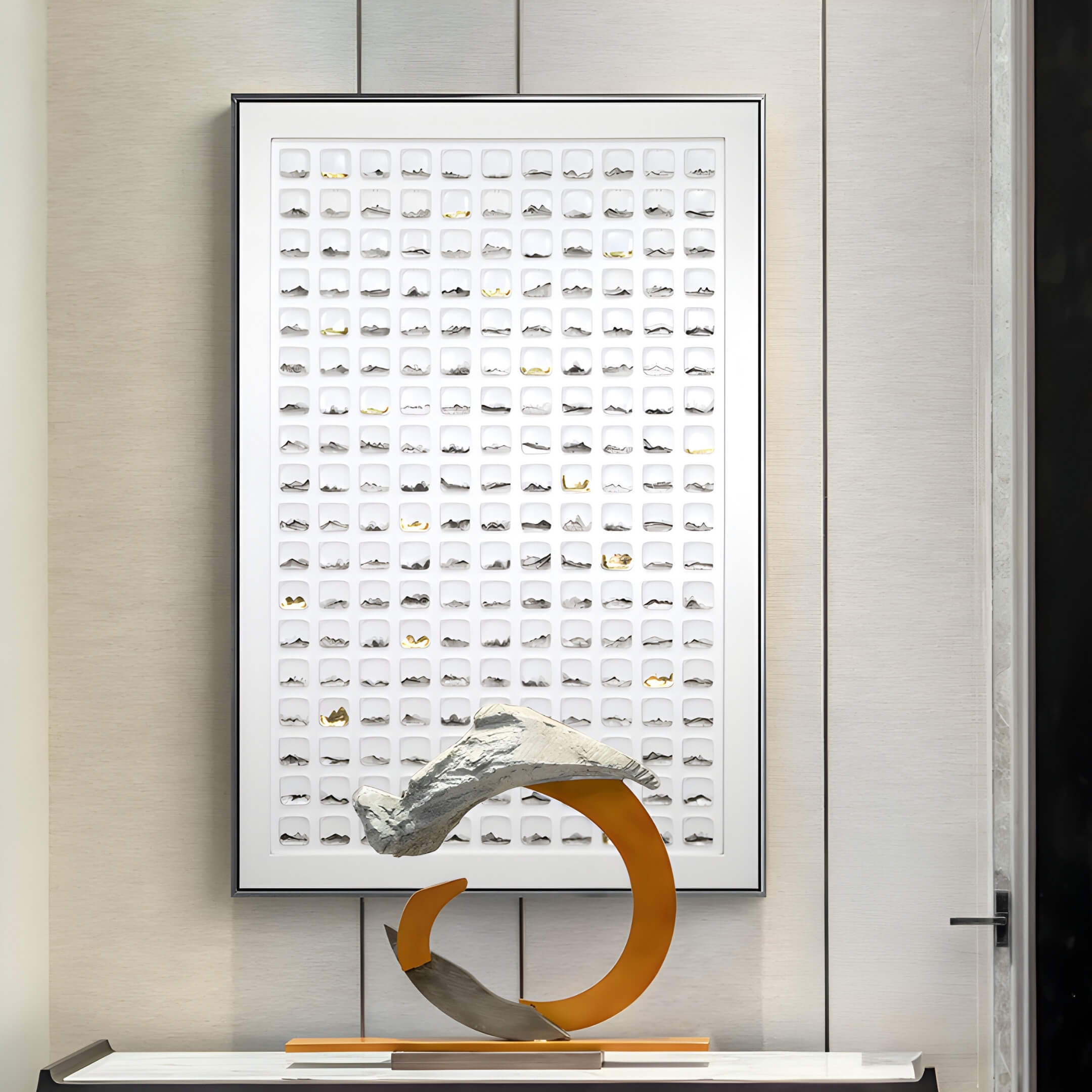 A modern art display includes a rectangular grid with raised white forms, a sculpture with a curved orange base holding a textured light-colored rock, and vertical walls adorned with the Luneve 3D Ceramic Wall Art With Gold Accents & Metal Border by Giant Sculptures.