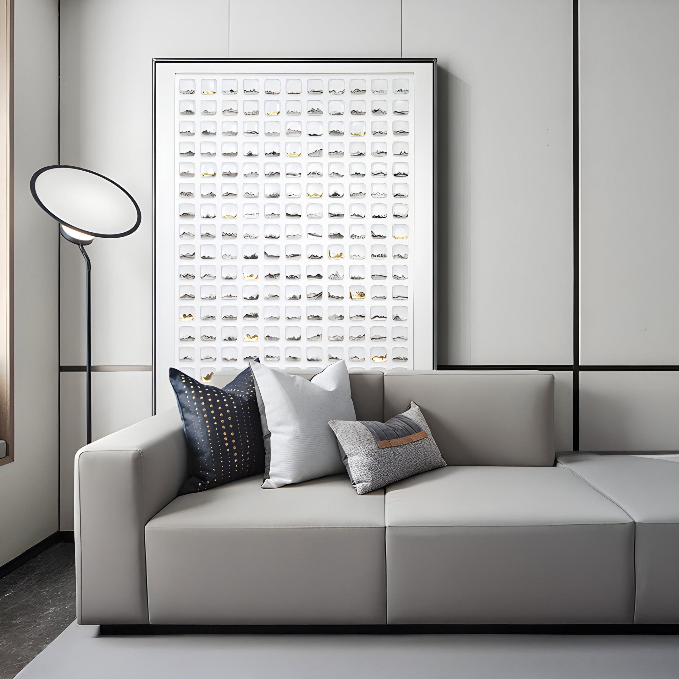 A modern living room showcases a light gray sofa with three decorative pillows. Behind it, the Giant Sculptures Luneve Gold Leaf 3D Ceramic Wall Art captivates with its hand-painted grid design. A sleek floor lamp with a circular shade stands nearby, illuminating the space.