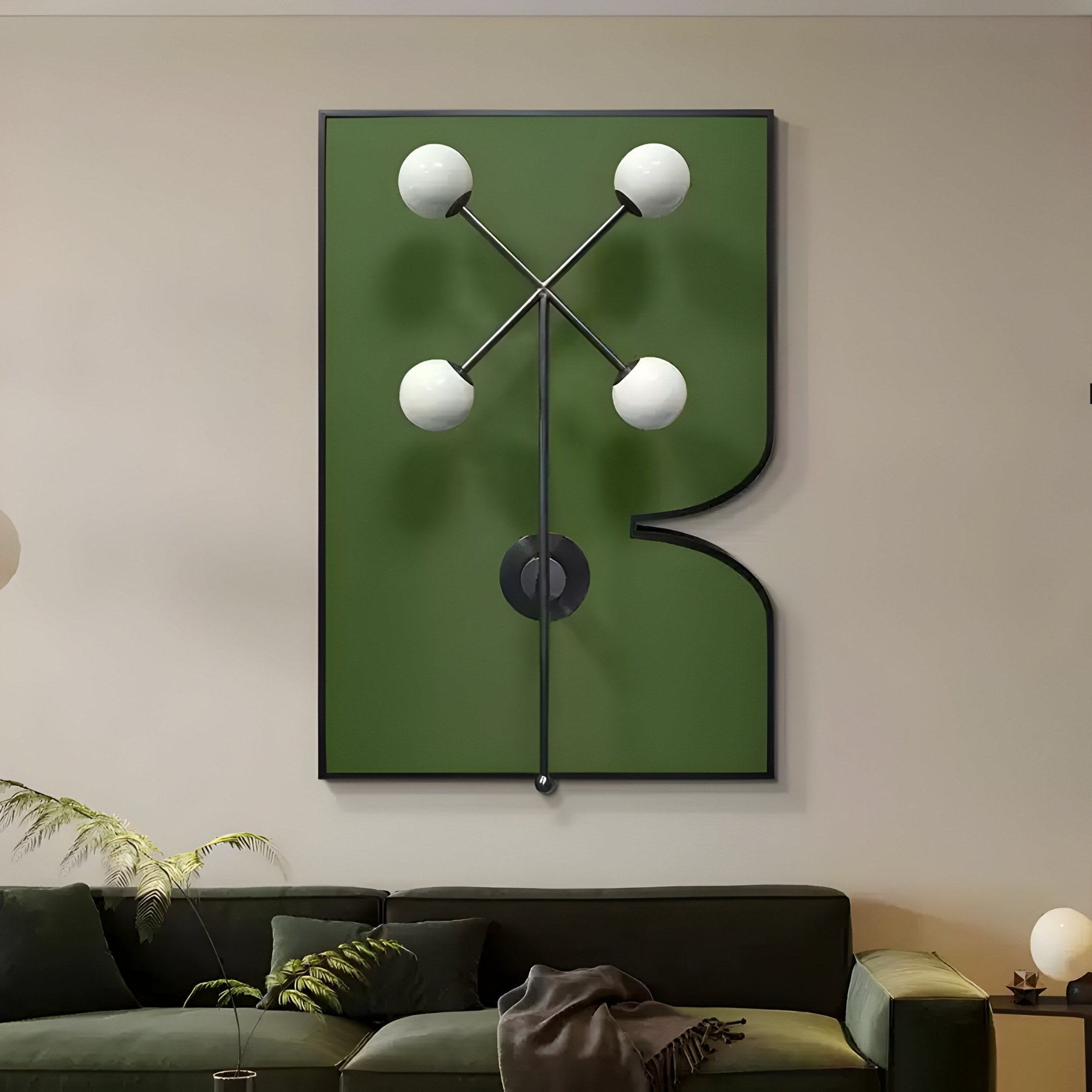 In a modern living room, the Axial Elegance Green Symmetrical Metal Wall Art by Giant Sculptures showcases a striking abstract design with black geometric shapes and white sphere accents. A dark green sofa enhances the minimalist decor, complemented by cushions and a small plant on the left.