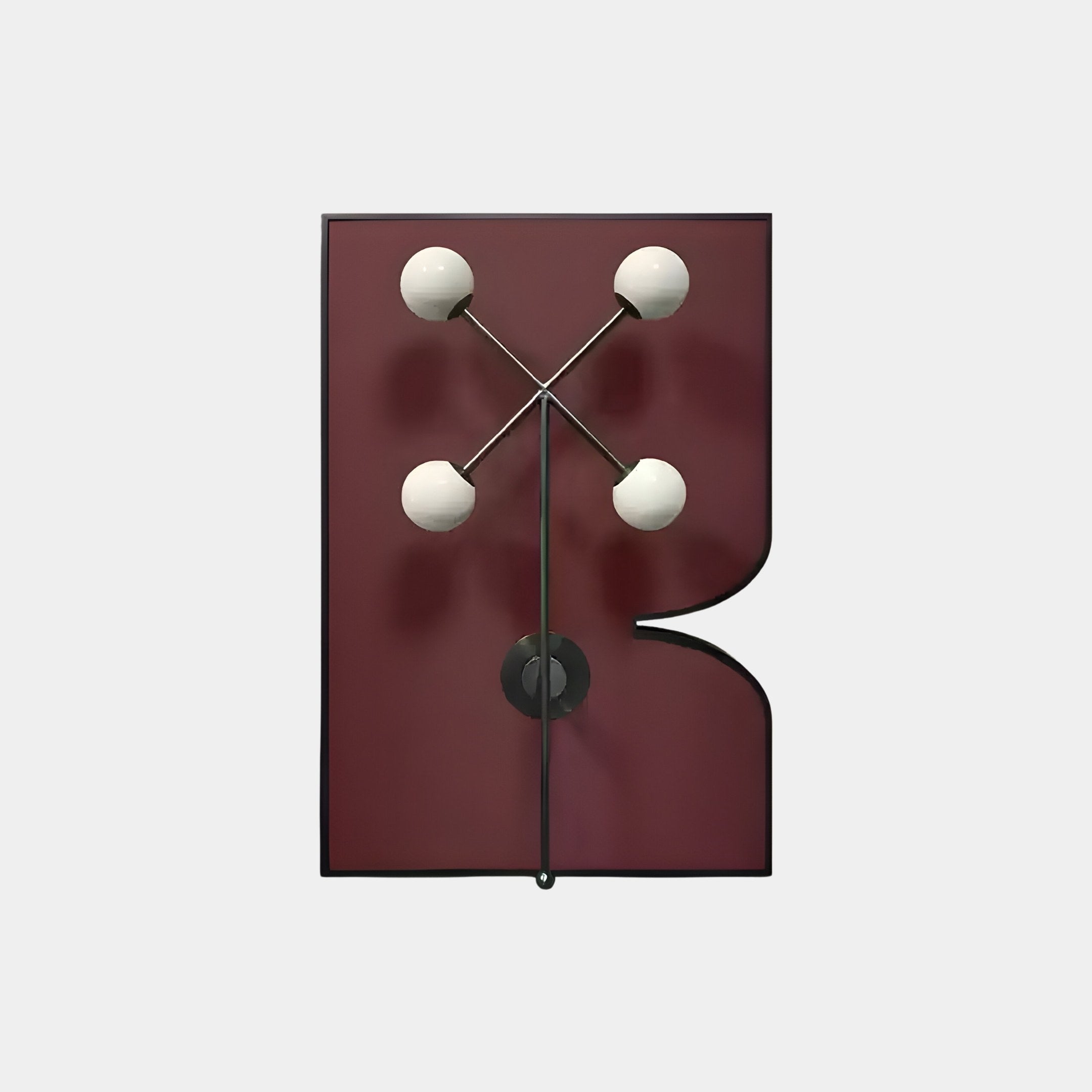 The Axial Elegance Burgundy Symmetrical Metal Wall Art by Giant Sculptures features a maroon rectangular base with a lower-right cut-out. Its sleek black metal structure and four white spherical bulbs in a cross pattern highlight modern geometry, blending form and function beautifully.