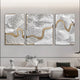 A modern living room showcases a pearl white textured sofa with a brown blanket and a round coffee table, adorned with a potted plant. The highlight is the Riverine Flow Pearl White Textured Triptych Wall Art by Giant Sculptures, featuring swirling textures and gold accents above the sofa.