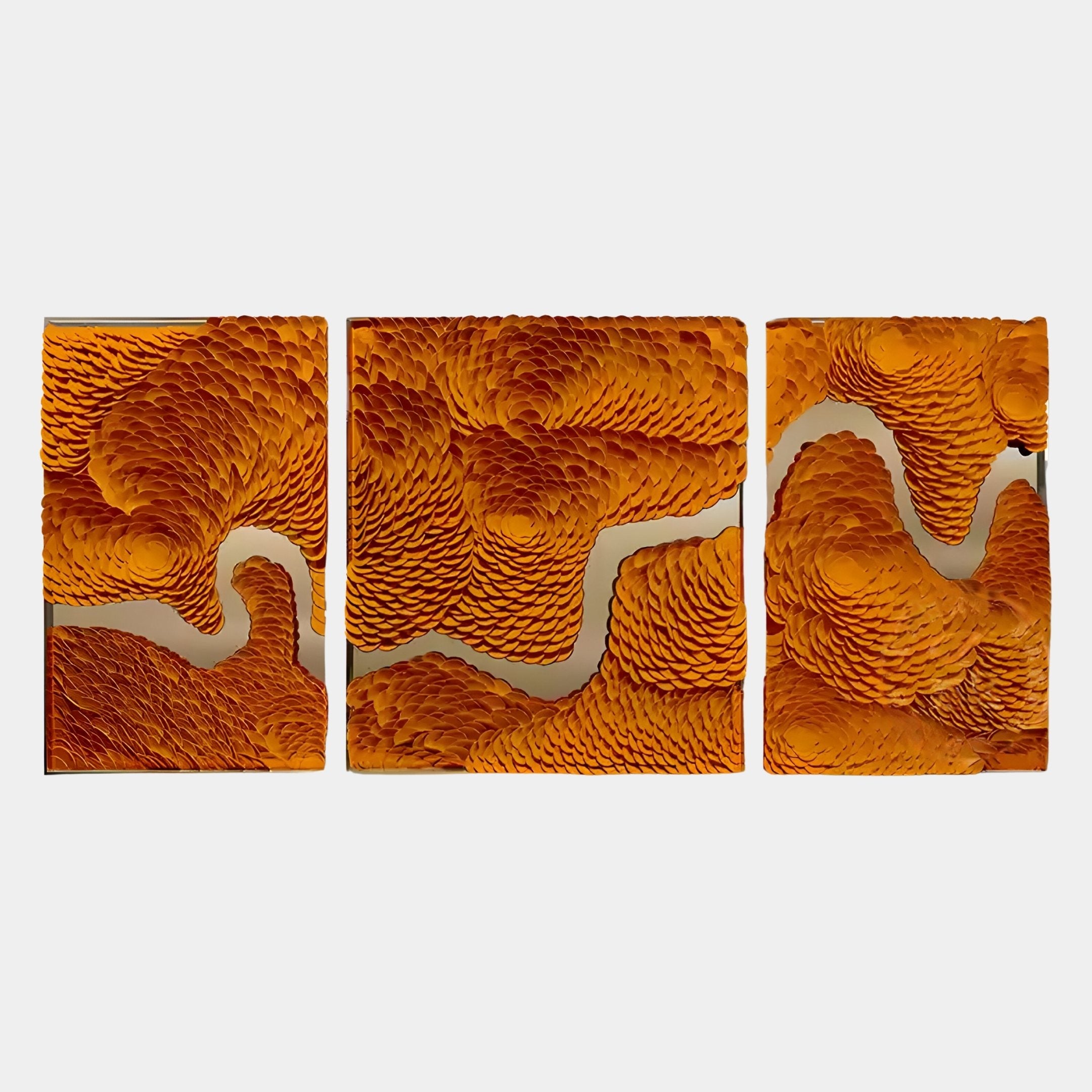 The Riverine Flow Golden Orange Textured Triptych Wall Art by Giant Sculptures features three rectangular panels with intricate, layered orange patterns and subtle stainless steel accents forming a continuous abstract design on a light background.