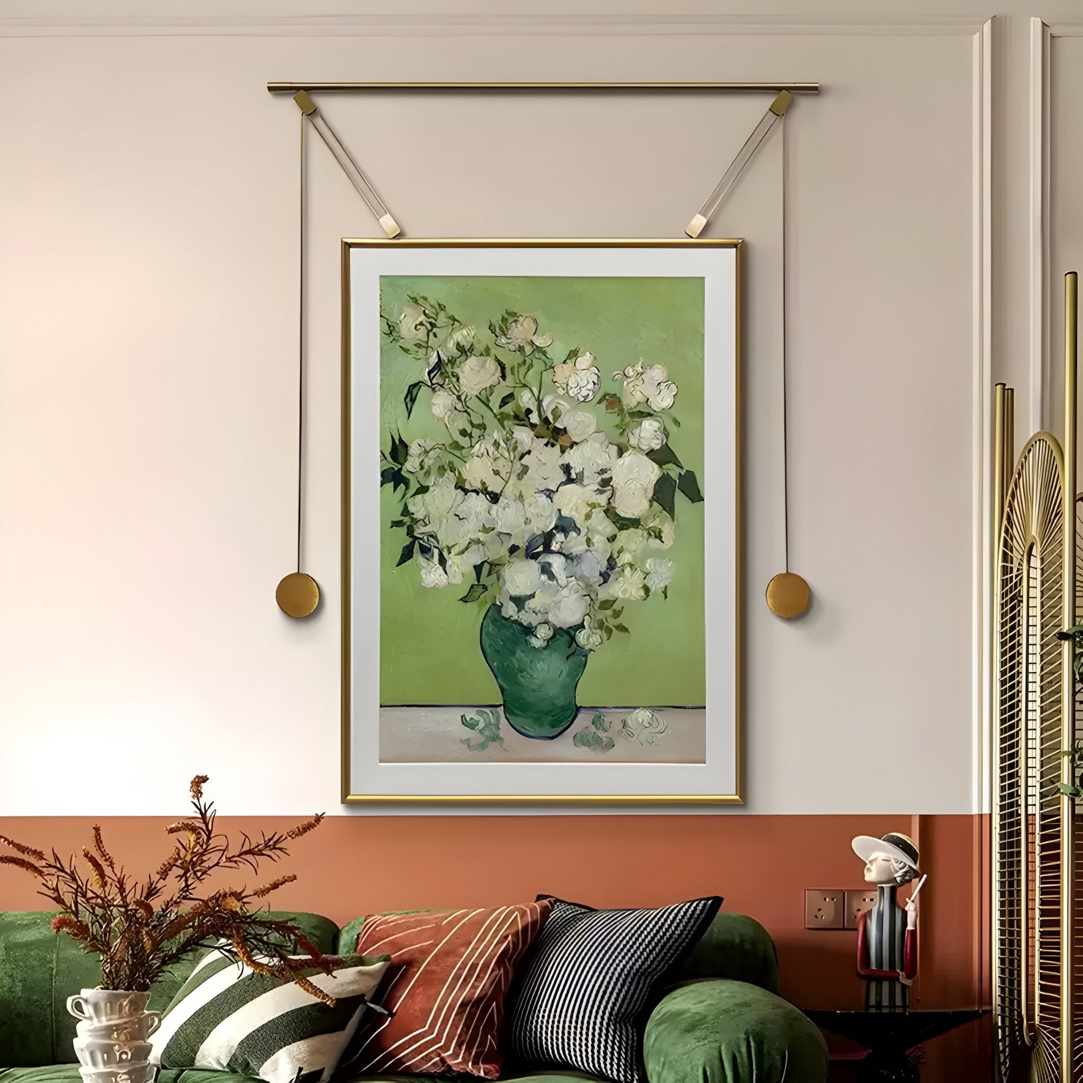 The Reverra White Blossoms Hanging Frame Wall Art by Giant Sculptures, with its light green background, graces the wall. Below, a green couch with striped pillows and a decorative branch completes the scene, while a small figurine on the side table enhances Natures Elegance Indoors.