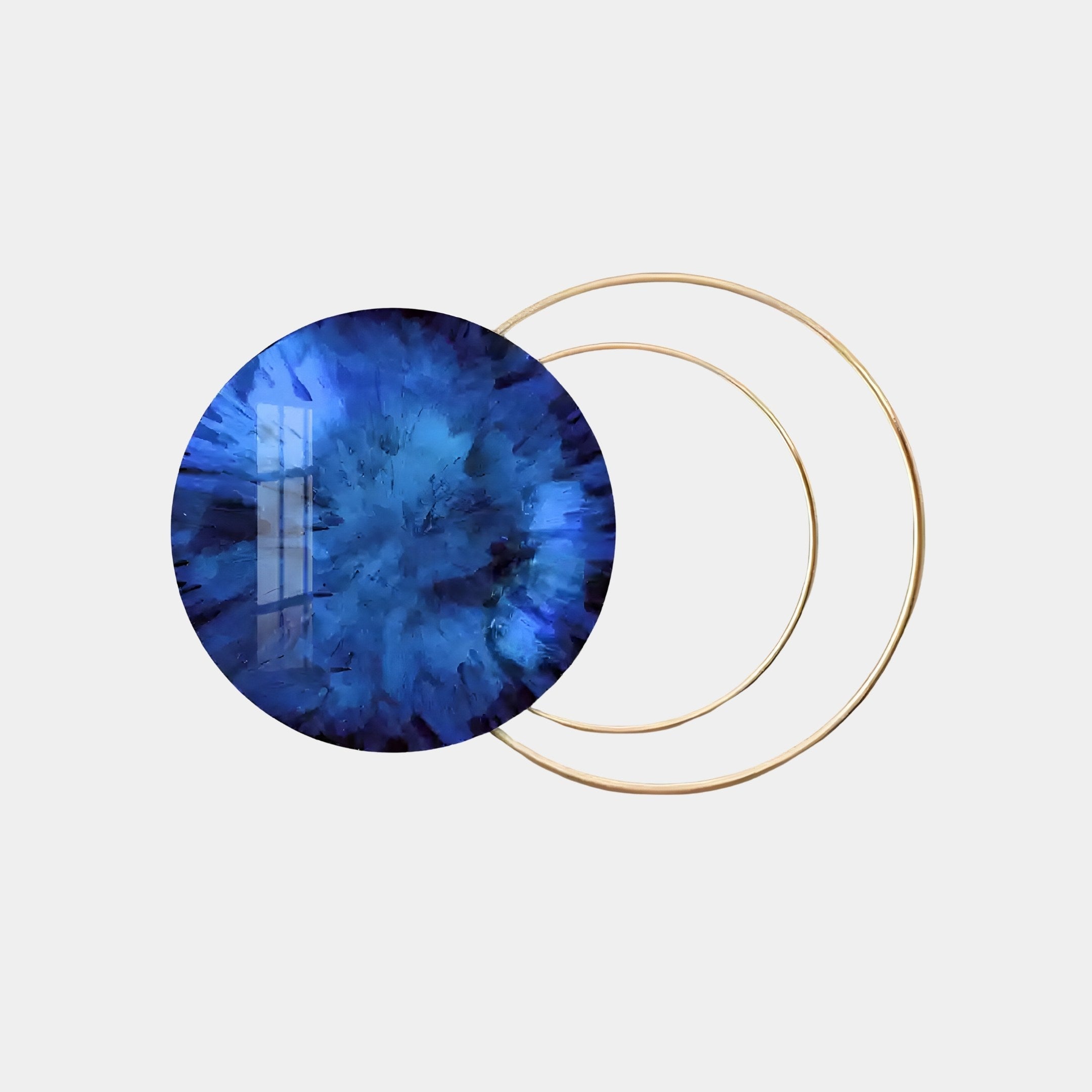 The Eclipse Luxe Sapphire Blue Circular Ring Wall Art by Giant Sculptures features a large, textured blue circle with abstract patterns overlapping two thin gold rings on a light gray background, creating an exquisite piece of art.