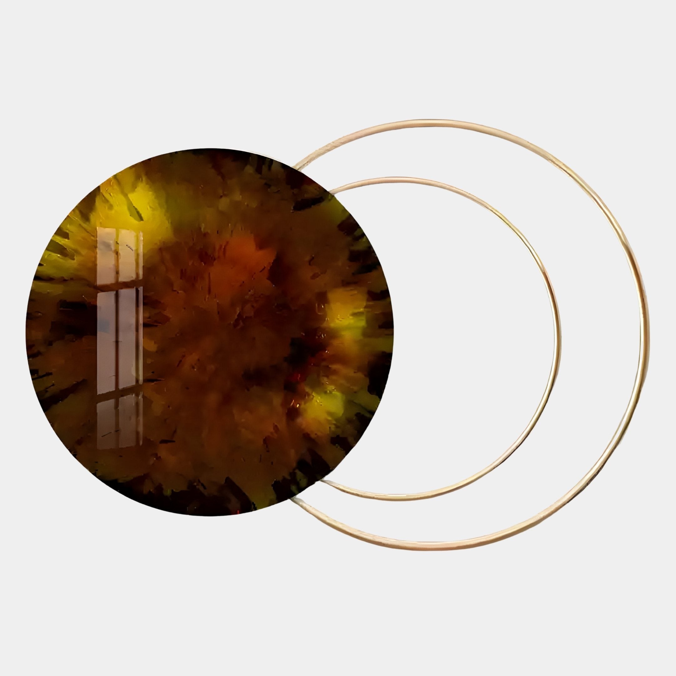 The Eclipse Luxe Amber Glow Circular Ring Wall Art by Giant Sculptures features abstract metallic gold rings on a light background in earthy brown, yellow, and orange tones, with a glossy surface that reflects light and adds an amber glow.