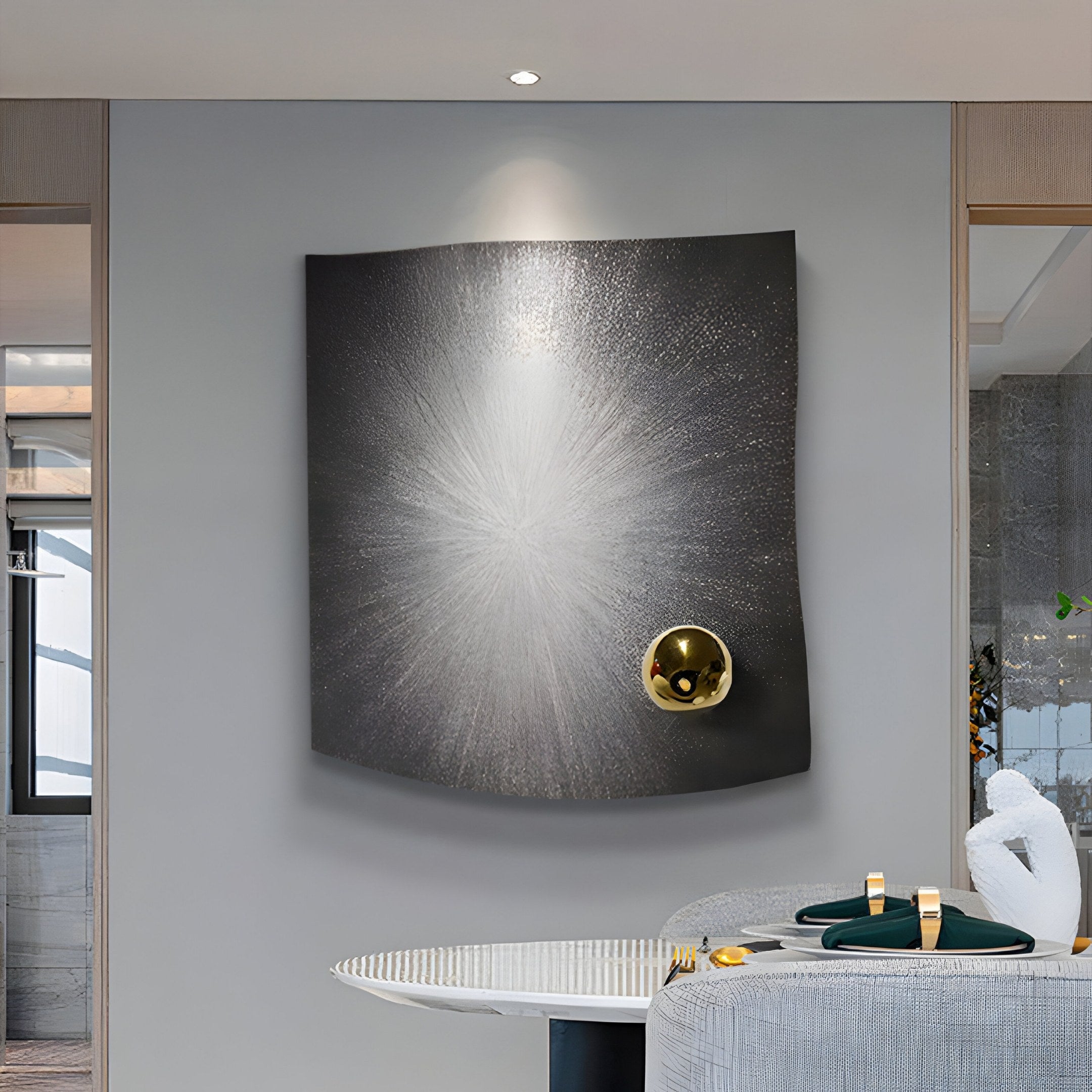 In a captivating display of silver radiance, the dining room features Giant Sculptures Astralis Silver Radiance Abstract 3D Wall Art with a silver burst design and golden sphere, complemented by an elegant round dining table and chairs in a softly lit contemporary style.