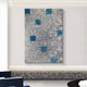 The Prismatica Blue & Silver Mosaic 3D Wall Art by Giant Sculptures exudes modern elegance with its abstract metallic design featuring a textured silver surface and scattered blue squares, adding depth and sophistication when mounted on a minimalist white wall above a concrete bench.