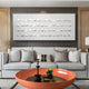 In a modern living room, a gray sofa with four decorative pillows is complemented by the Lureva 3D Ceramic Wall Installation With Gold Foil & Metal Trim from Giant Sculptures above. A round orange coffee table features a black decorative piece and a small plant as an inviting focal point.