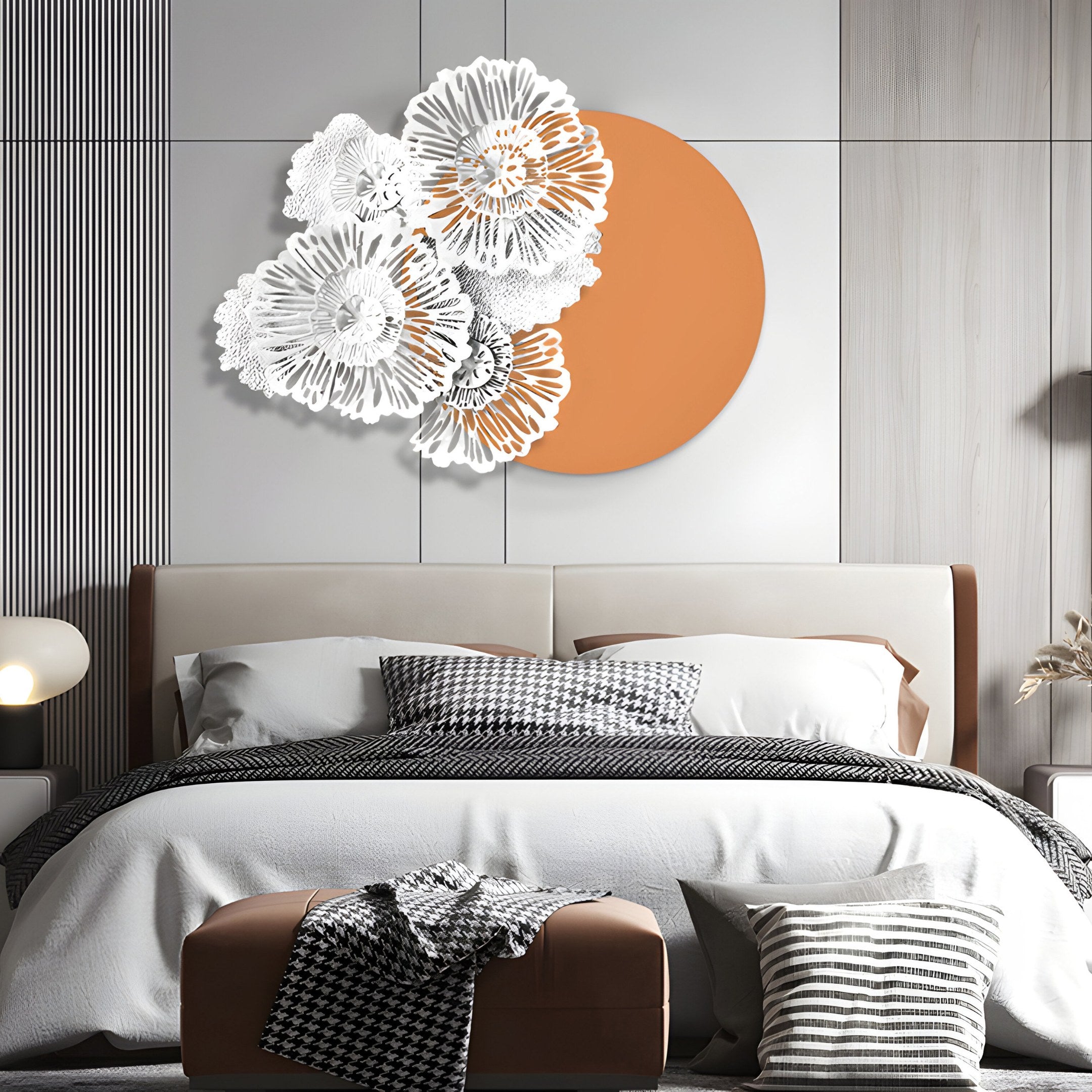 A modern bedroom displays a bed with houndstooth-patterned pillows and blanket. Above it is the Fleur Halo Terracotta Round White Metal Floral Decorative Wall Art by Giant Sculptures. The room features a neutral palette and contemporary furnishings.