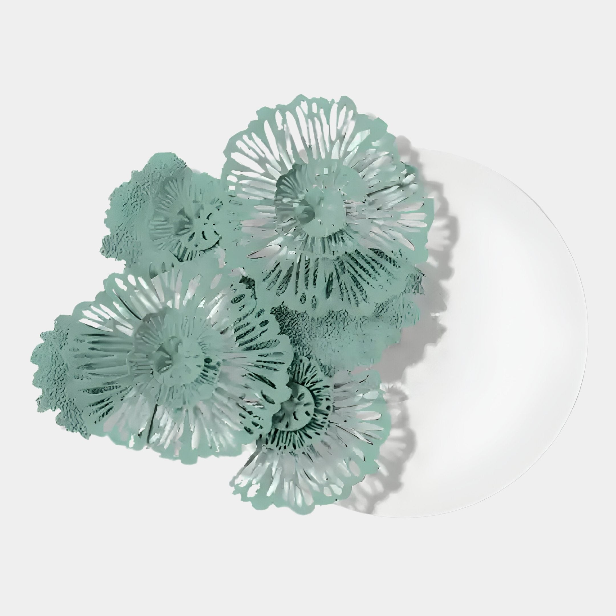 The Fleur Halo White Round Green Metal Floral Decorative Wall Art by Giant Sculptures features intricate, layered teal and green floral designs, artistically arranged for a striking nature-inspired effect.