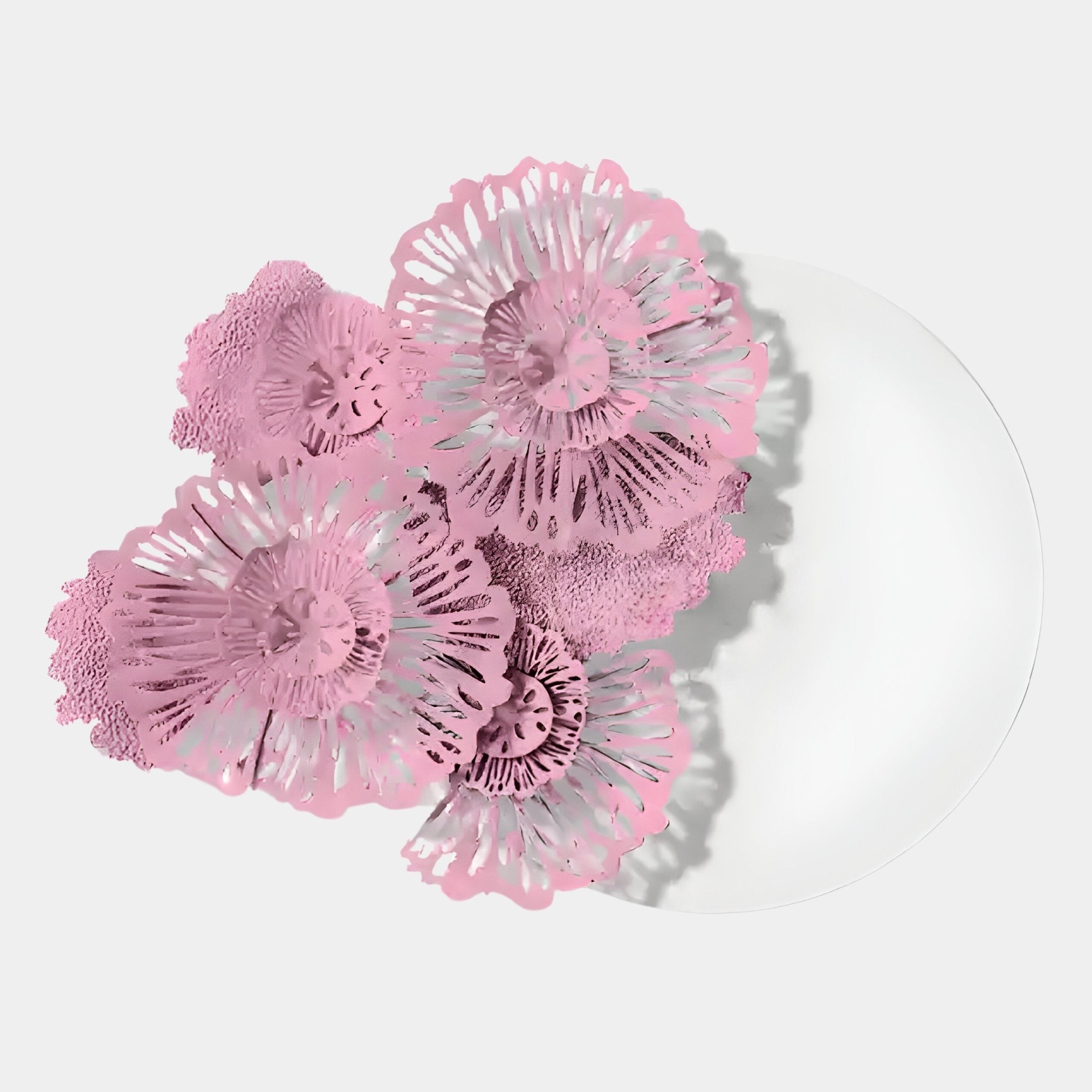 The Fleur Halo White Round Pink Metal Floral Decorative Wall Art by Giant Sculptures features a white plate partly adorned with clustered, intricate pink metal flowers, creating a delicate and artistic display on one side.