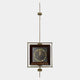 The Ethereal Frames Golden Tree Classic Suspended Wall Art by Giant Sculptures features a circular gold tree pattern on a dark background, suspended vertically by a metal rod with geometric brass fittings—a contemporary statement piece.