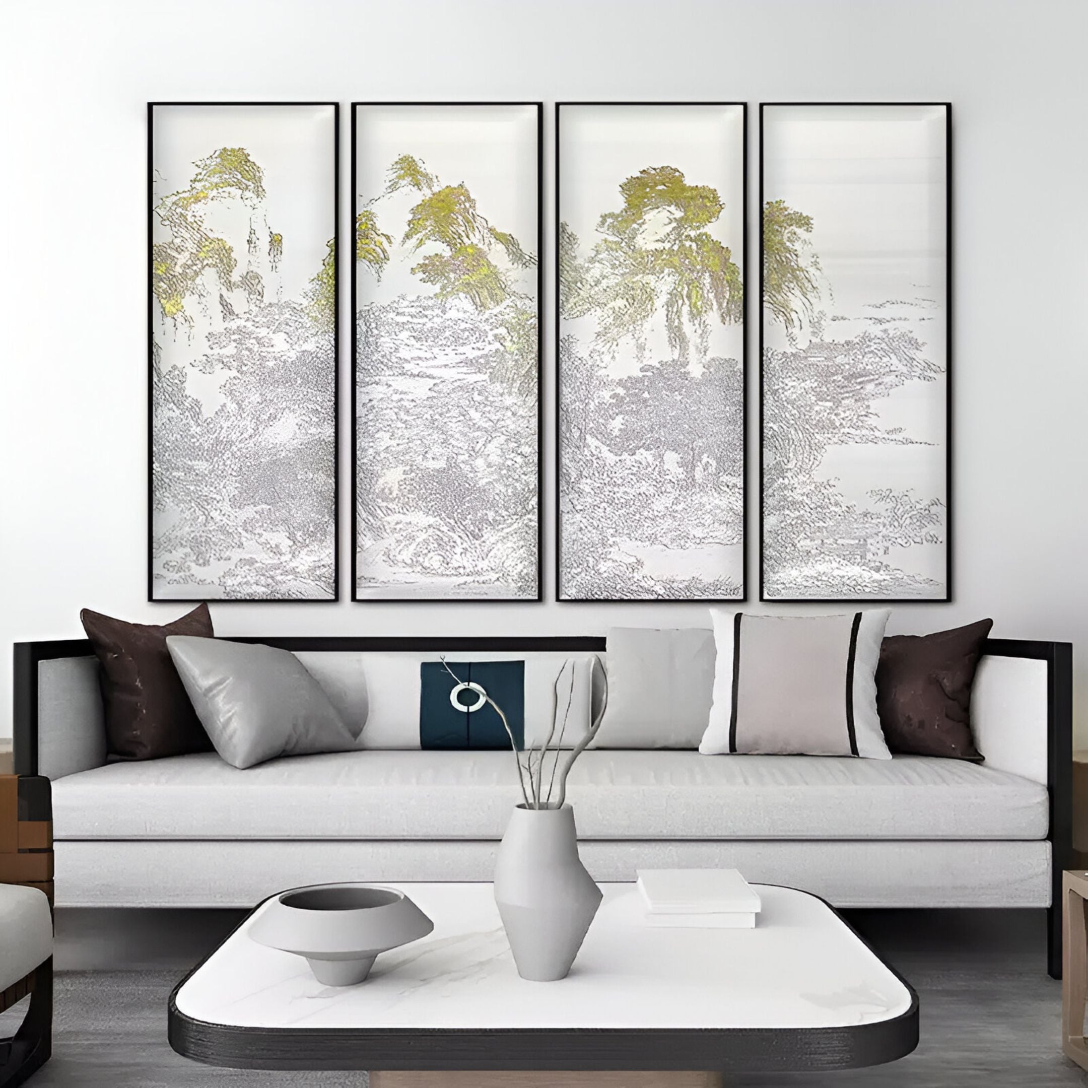 A modern living room showcases a white sofa adorned with various pillows and a minimalist center table. Behind it, the Velantra Multi-Panel Silk Artwork by Giant Sculptures displays intricate natural detailing of trees and mountains in muted tones on a light background.