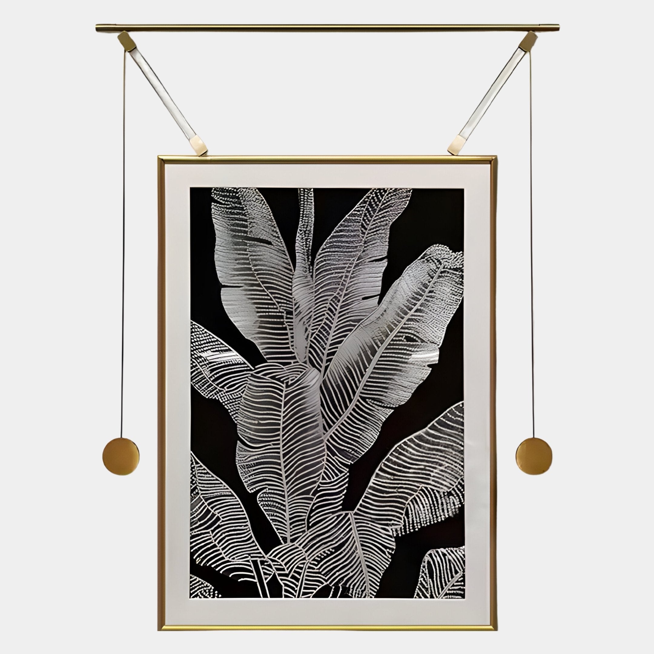 The Glacia Monochrome Botanical Crystal Hanging Framed Wall Art by Giant Sculptures features detailed white banana leaves on black, set in a gold frame with rods and golden weights, showcasing contemporary craftsmanship.