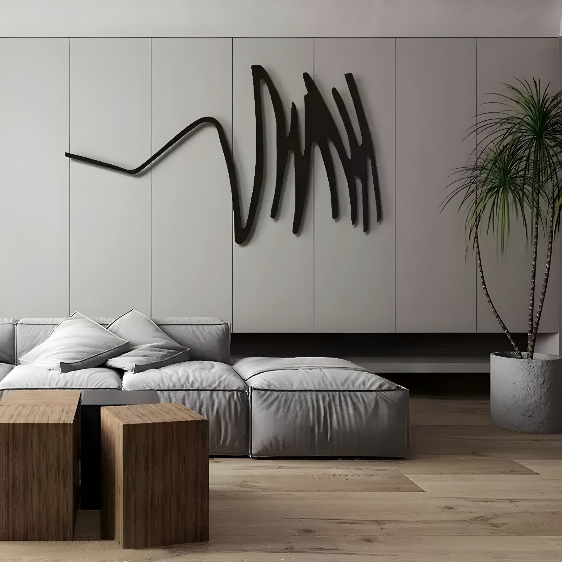 A modern living room radiates sophistication with a sleek gray couch and white pillows, complemented by Giant Sculptures Oscura Dynamic Flow Black Abstract Metal Wall Art. Wooden cube coffee tables and a tall potted plant enhance its elegance on a sleek hardwood floor.