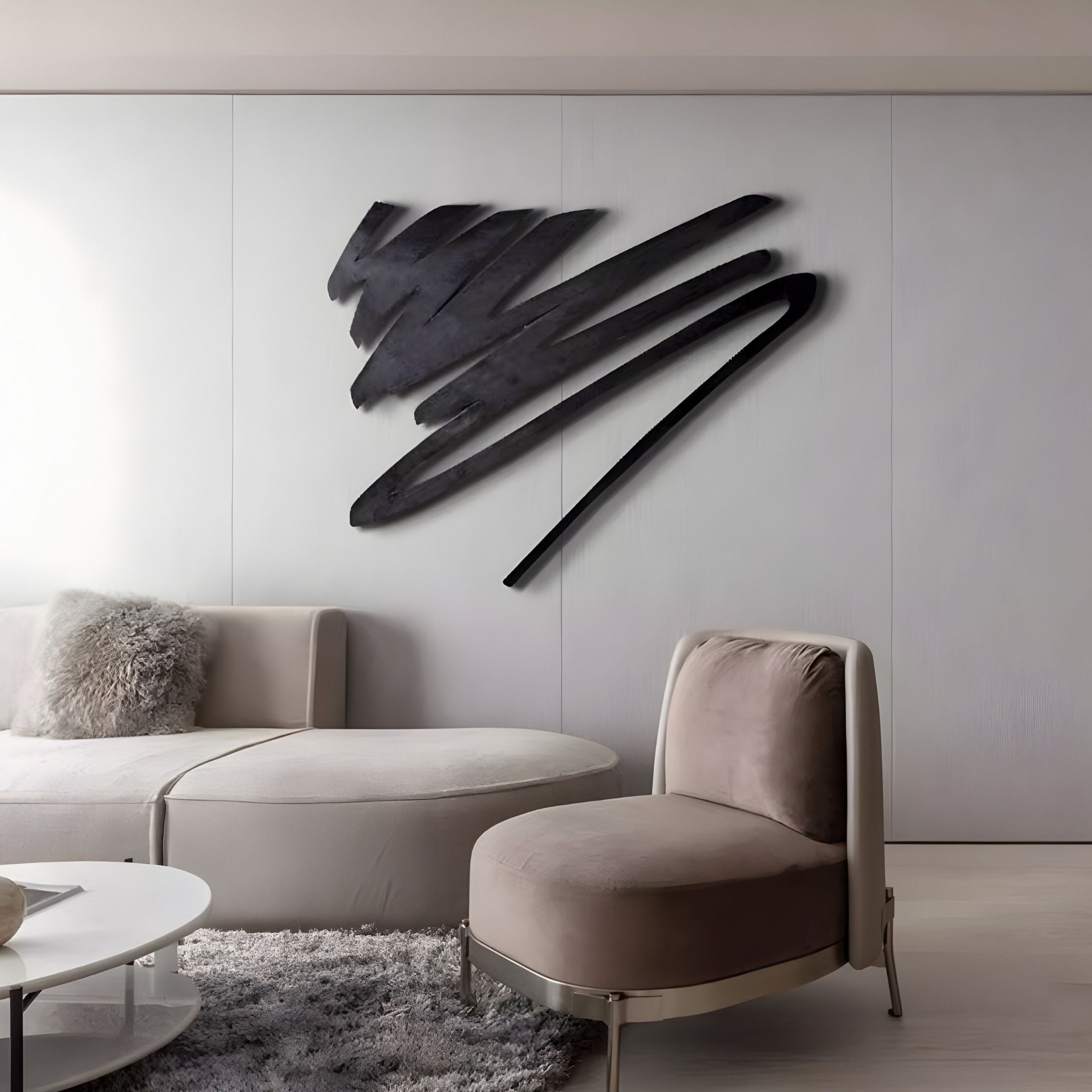 A modern living room features a curved beige sofa, plush armchair, and round white coffee table on a gray carpet. The Oscura Wave Crest Black Abstract Metal Wall Art by Giant Sculptures is mounted on the smooth white wall, adding a contemporary touch to the minimalist decor.