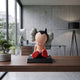 Fiery Red Iconify Bobblehead Cosmic Boy Figure, 10cm vinyl piece on black base, shown rear-view on a desk in an office setting with a monitor and floor lamp.