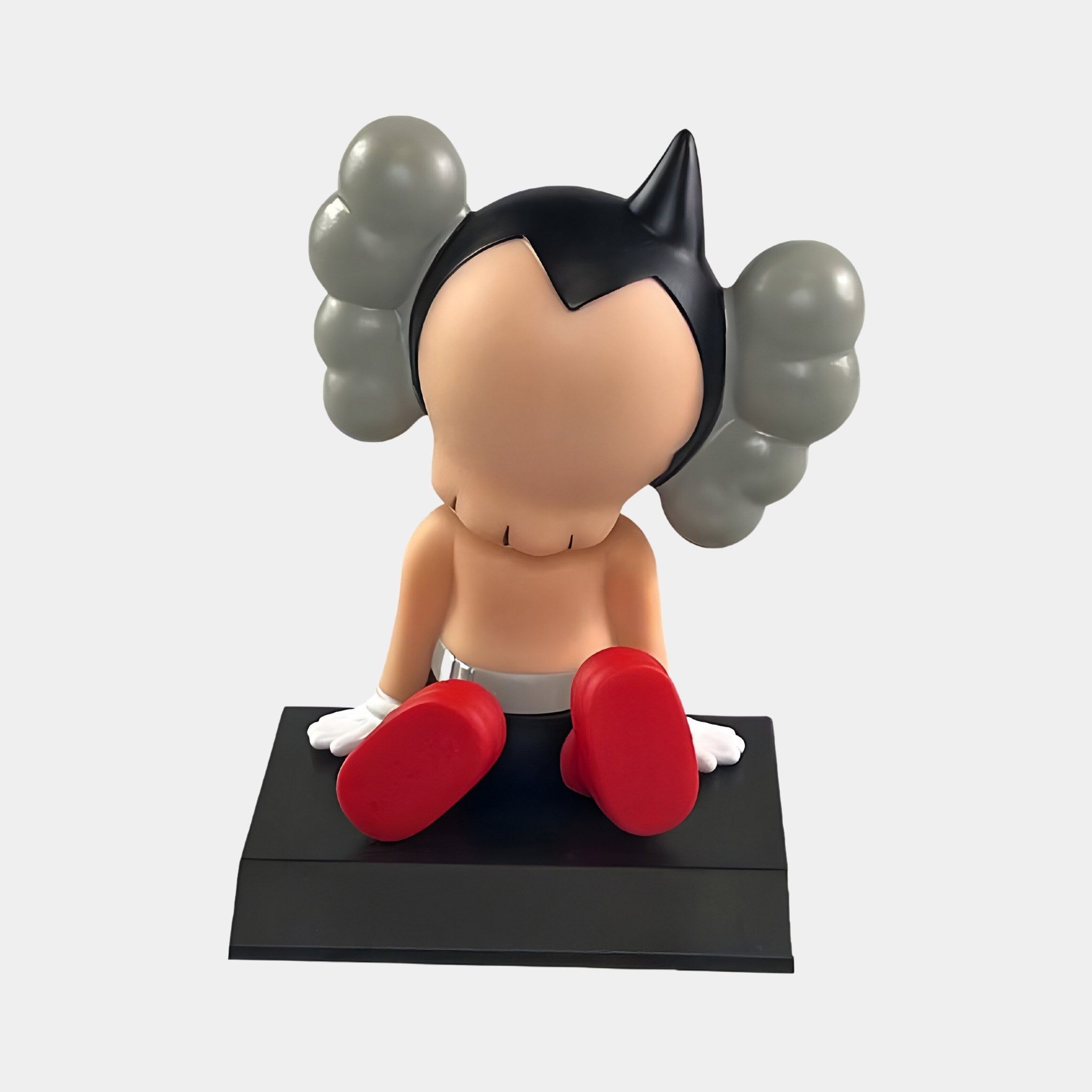 Introducing the 10cm Fiery Red Iconify Bobblehead Cosmic Boy Figure by Giant Sculptures: a vinyl collectible with a smooth, featureless face, unique gray head extensions, red shoes, white gloves, black shorts, and a black platform—perfect for any enthusiast.