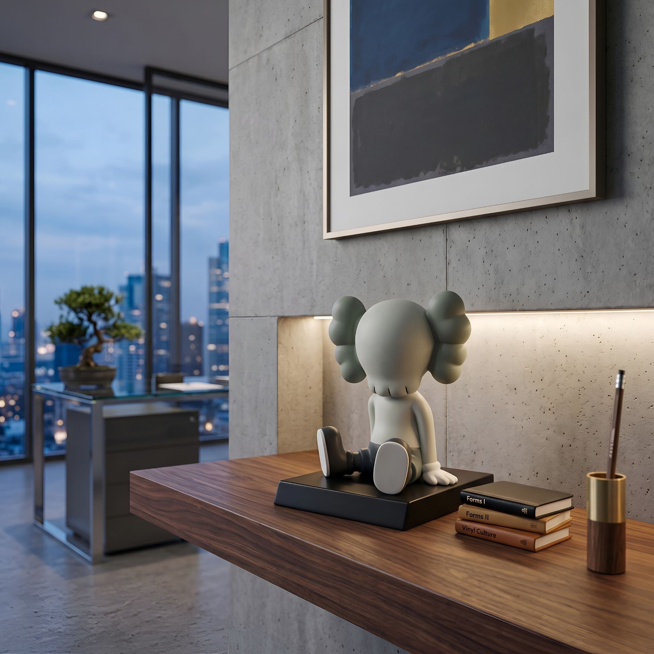 Dove Grey I Iconify Bobblehead Figure, 10cm, seated on black platform on a walnut desk against a concrete wall with framed art, in a city-view apartment setting.