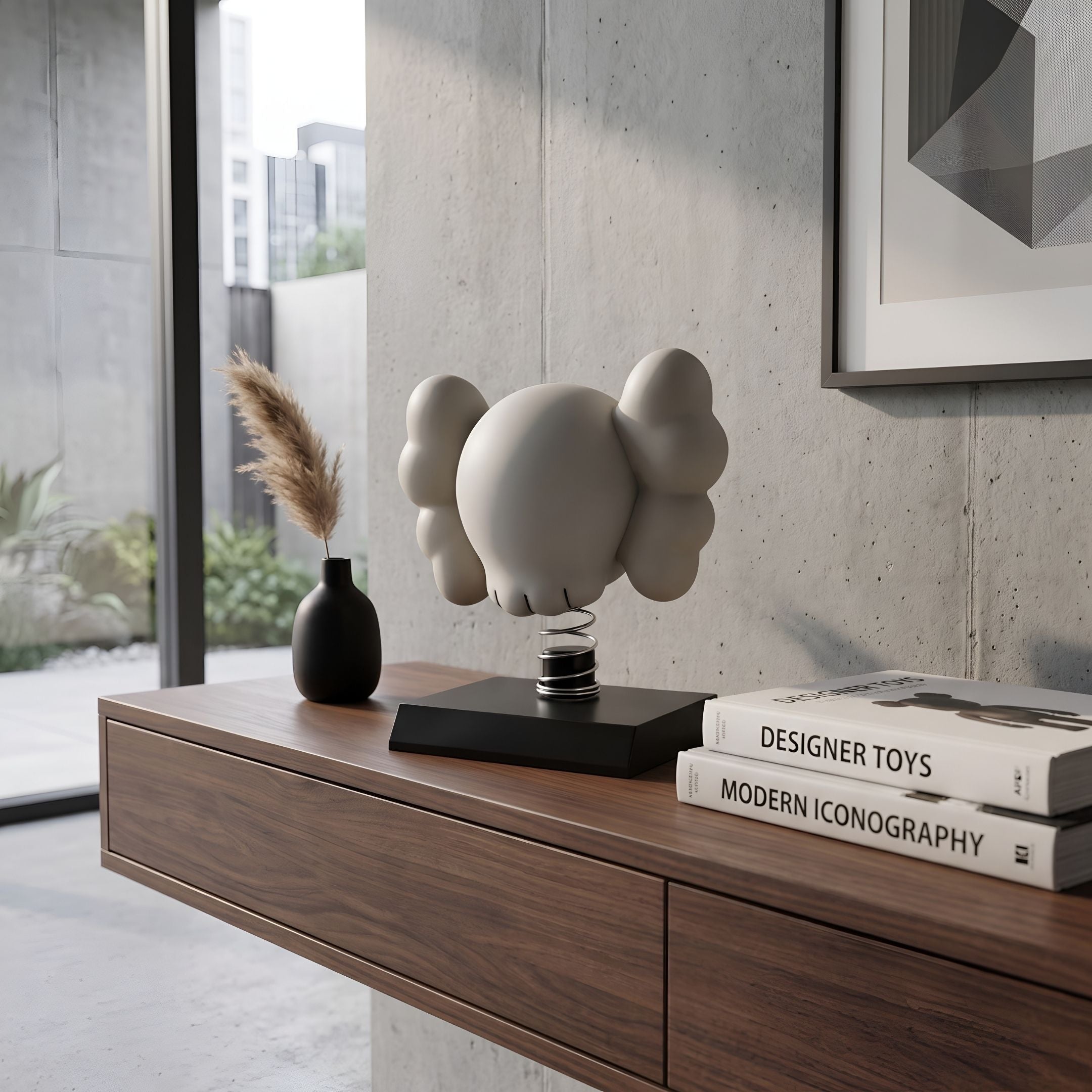 Dove Grey II Iconify Bobblehead Figure, 10cm, on a black base with spiralled metal stand, shown on a walnut console beside books and a black vase in a modern room.