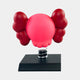 The Blush Ruby Iconify Bobblehead Figure by Giant Sculptures is a red, balloon-like sculpture with large ears and a simplified face on a black rectangular base, resembling a cartoonish figure with puffy arms that capture its whimsical charm.