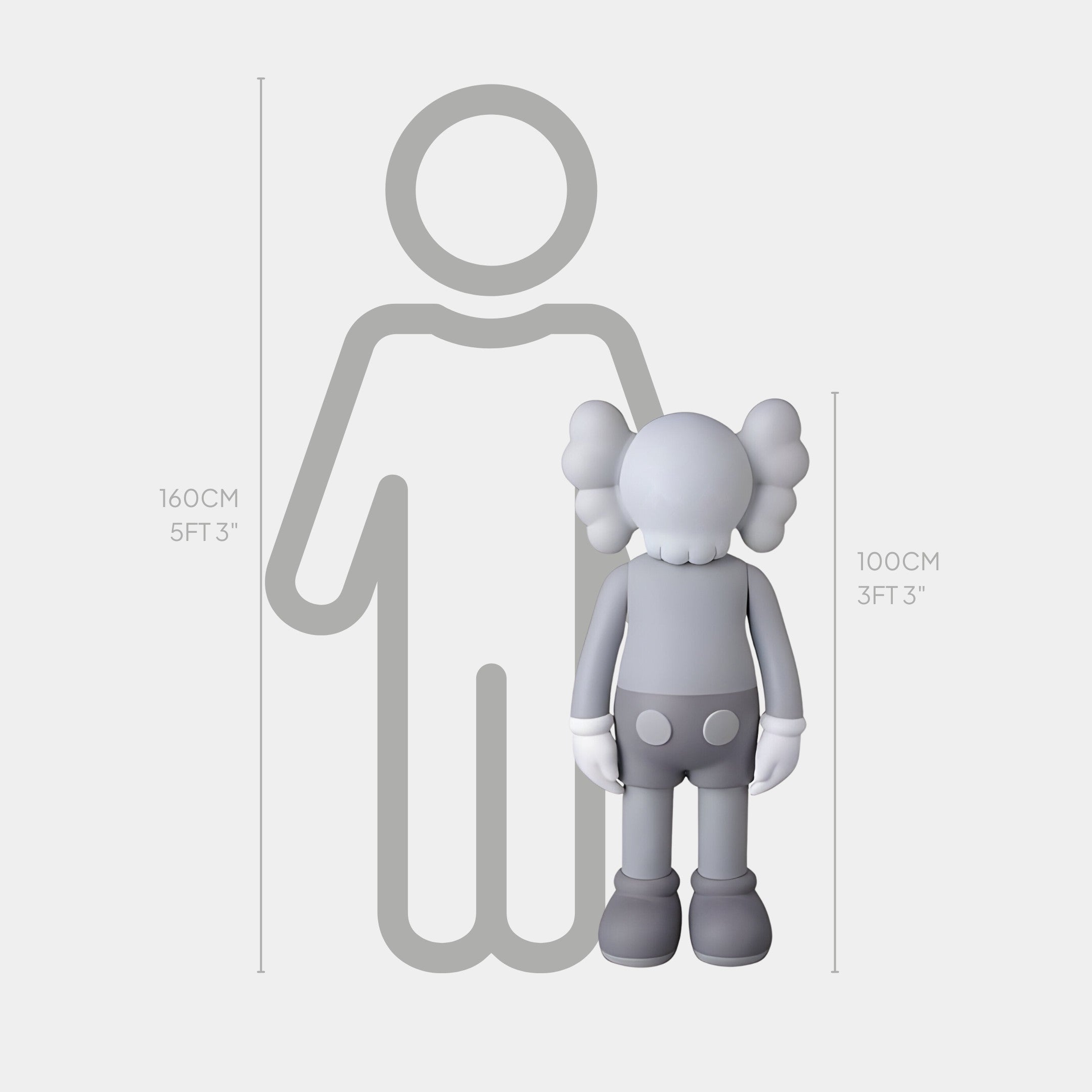 The Soft Grey Iconify Standing Sculpture by Giant Sculptures, standing at 100 cm (3 ft 3 in), showcases minimalist elegance next to a human figure of 160 cm (5 ft 3 in). This cartoon-like character is distinguished by cross-shaped eyes and glove-like hands.