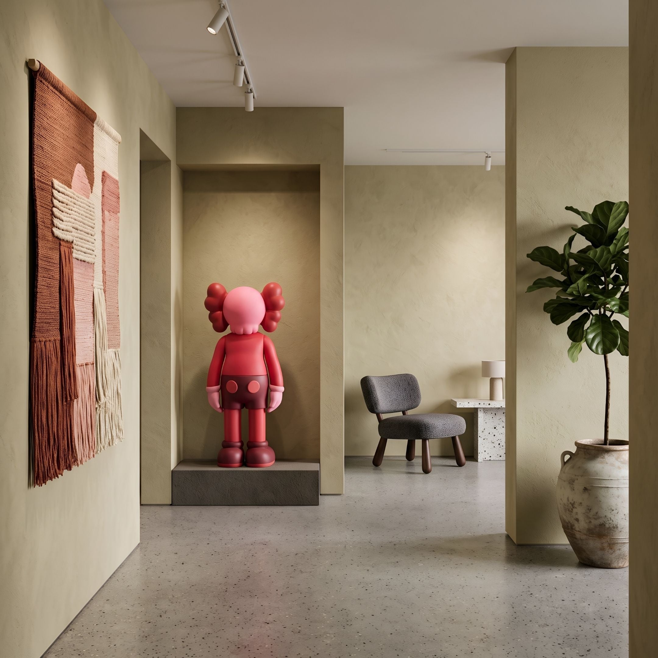 Blush Ruby Iconify Standing Sculpture, 100cm, in a wall niche within a modern room featuring a grey armchair, woven wall hanging, and potted plant.