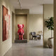 Blush Ruby Iconify Standing Sculpture, 100cm, in a wall niche within a modern room featuring a grey armchair, woven wall hanging, and potted plant.