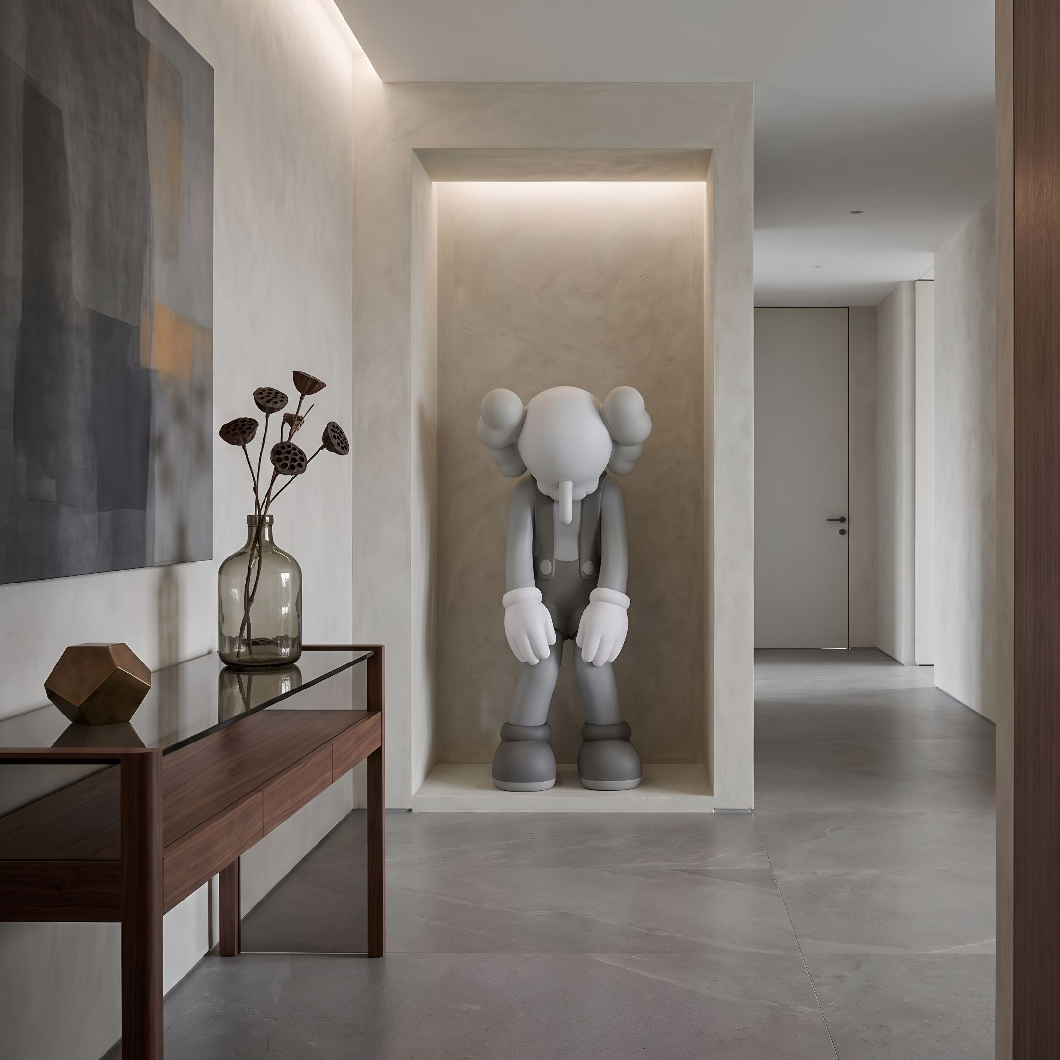 Slate Grey Iconify Burden Sculpture, 130cm, in a wall niche in an entryway with a console table, vase, and framed art nearby.
