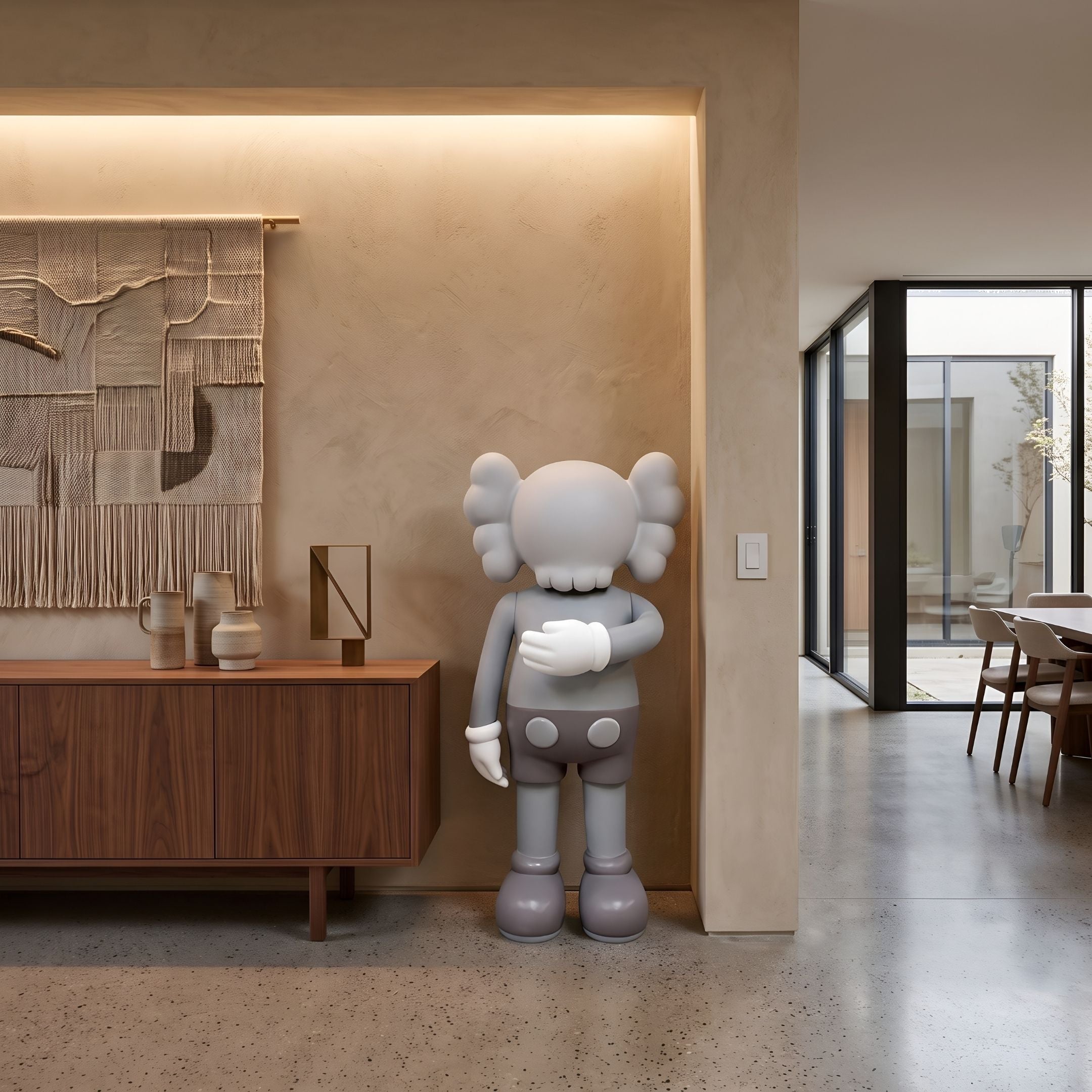 Soft Grey Iconify II Dance Sculpture, 130cm, standing figure with crossed-bones ears and gloved hands, shown beside a wooden sideboard in a neutral-toned living space.