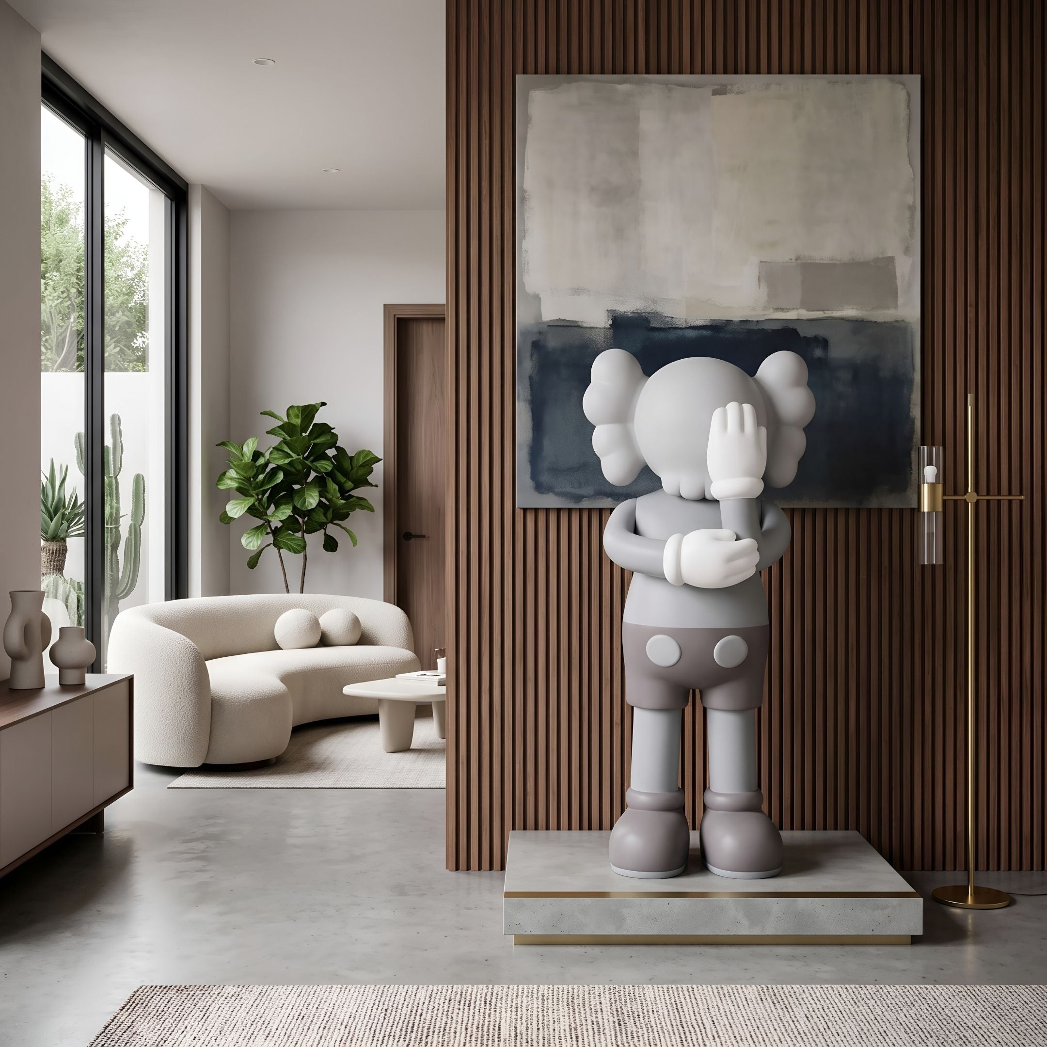 Soft Grey Iconify IV Dance Sculpture, 130cm, on a stone and brass base in a living room with abstract wall art, sofa, and wood-paneled walls.