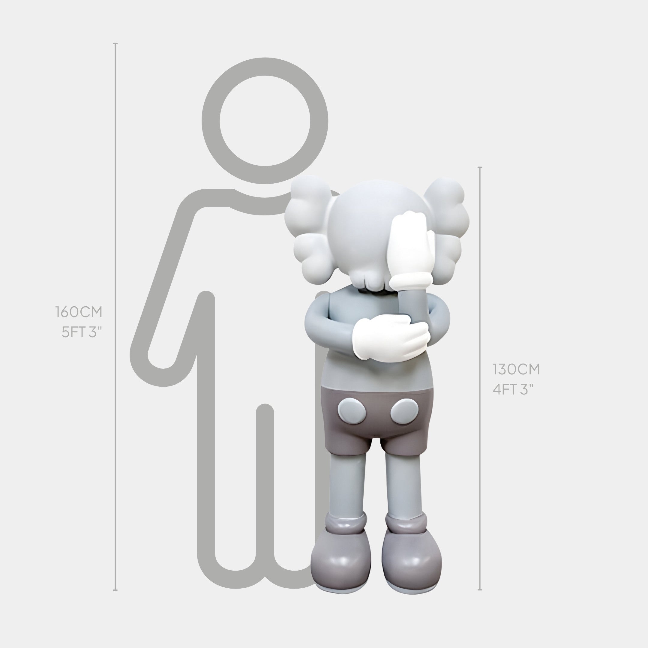 A cartoonish figure by Giant Sculptures is 130 cm tall, standing before a 160 cm silhouette. The Soft Grey Iconify IV Dance Sculpture features a round head, gloved hands covering its face, and buttoned pants in a minimalist style.