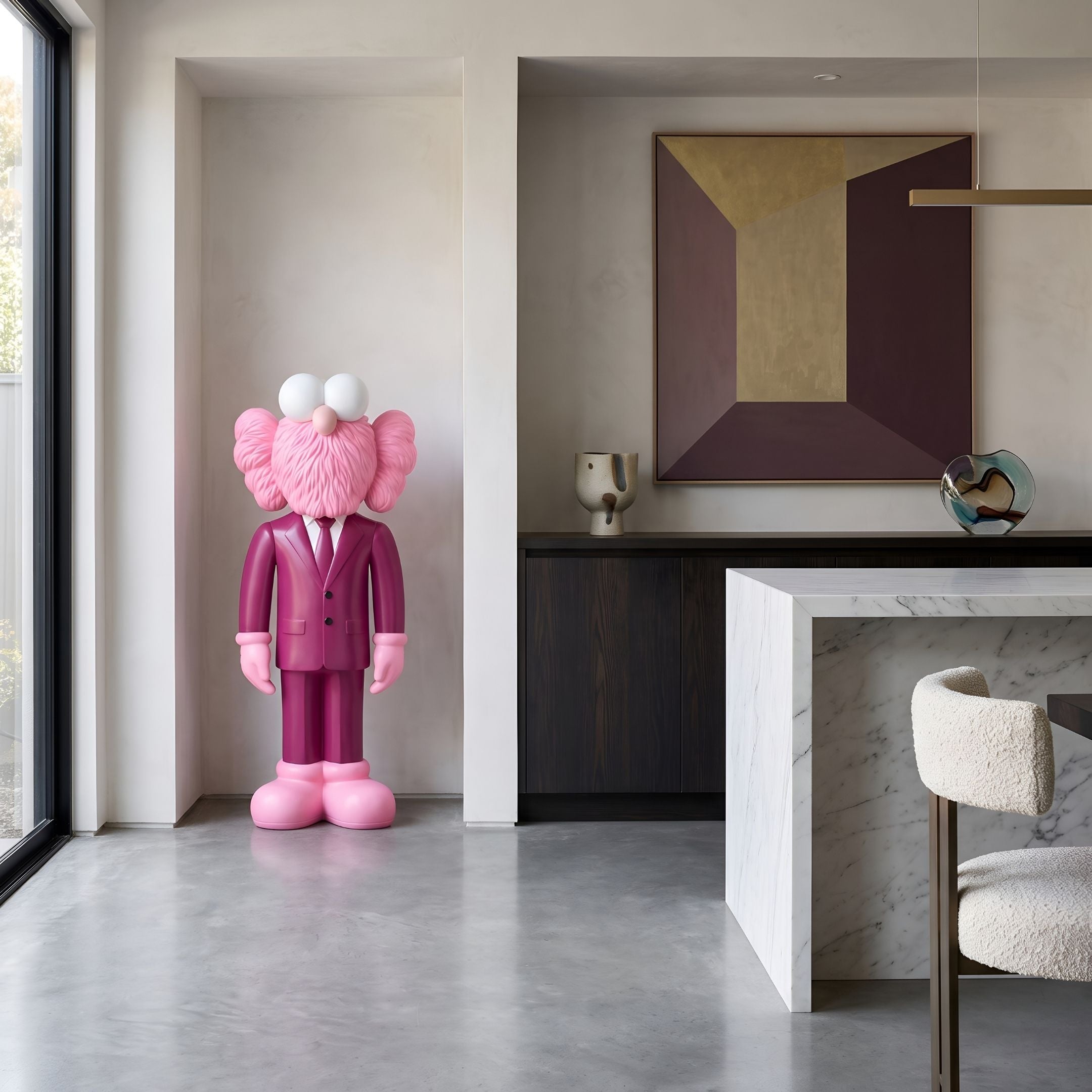 Deep Magenta Suit Iconify CEO Sculpture, 130cm, pink resin figure in a magenta suit, displayed in an alcove near a marble kitchen island.