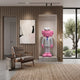 White Suit Iconify CEO Sculpture, 130cm, pink figure in white suit and blue tie on stone plinth in wall niche, beside chair and abstract art.