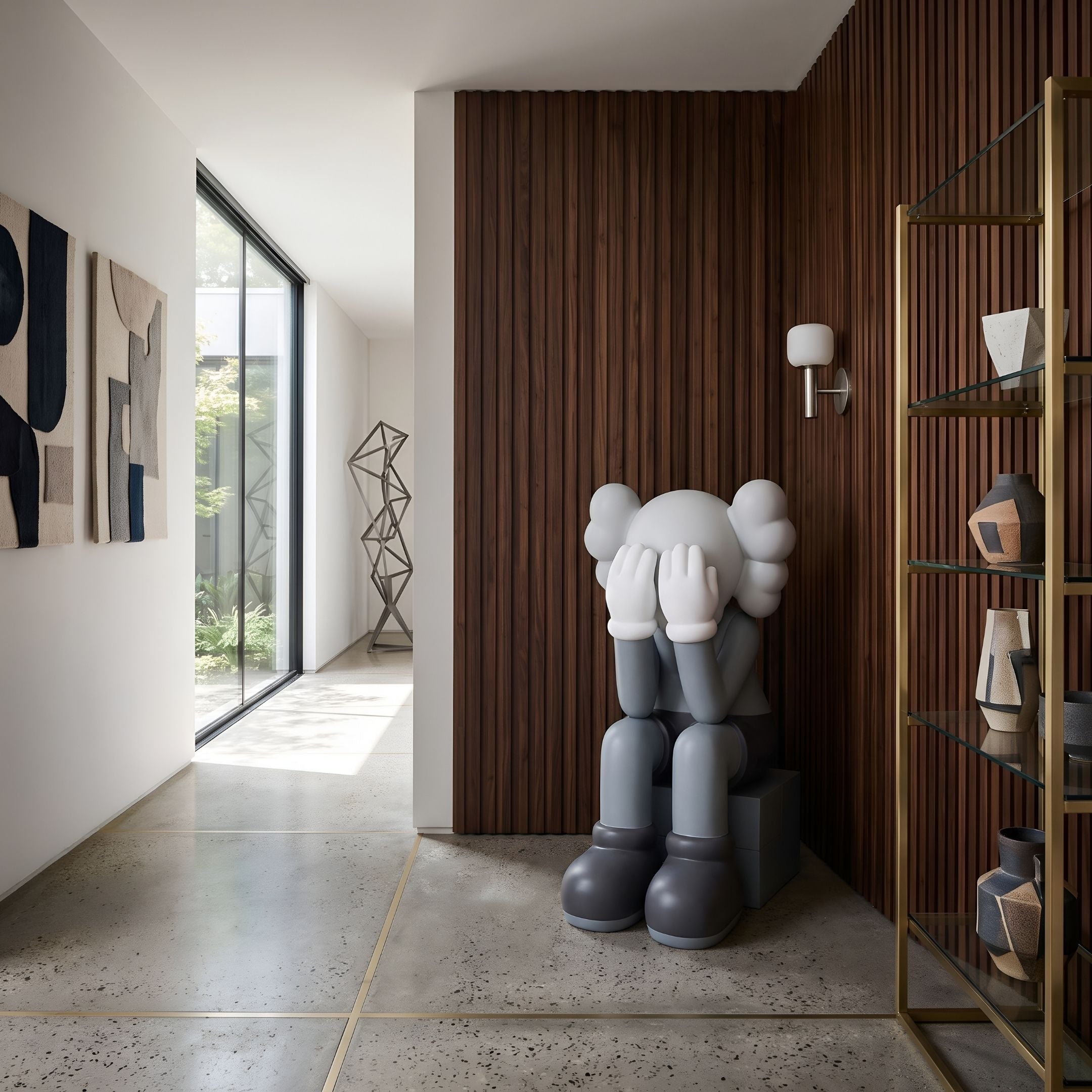 Slate Grey Iconify Melancholy Sitting Sculpture, 130cm, seated on a grey block with head in hands, displayed near a wood-paneled wall in a modern hallway.