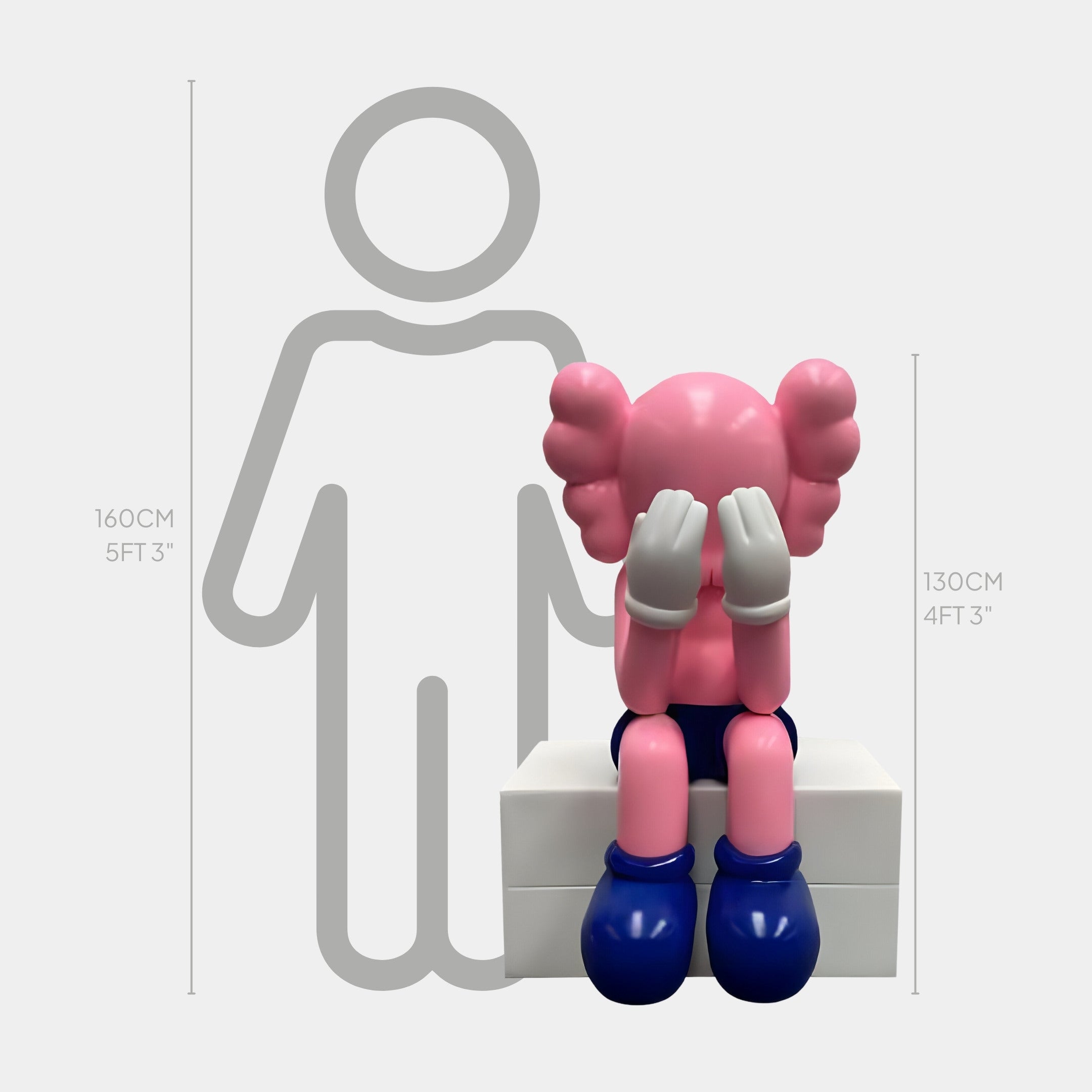 The Petal Pink Iconify Melancholy Sitting Sculpture by Giant Sculptures is a modern pop-art piece in a cartoon-like style. It features a figure hiding its face with gloved hands, wearing large blue shoes, and sitting 130cm (4ft 3in) tall, contrasted against an adult shadow of 160cm (5ft 3in).