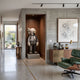 Slate Grey Iconify Anatomy Sculpture, 130cm, displayed on a concrete pedestal in a wood-paneled hallway niche near a green leather lounge chair.
