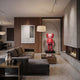 Blush Ruby Iconify Standing Sculpture, 130cm red resin figure on a black platform beside a floor lamp, fireplace, and dark sofa in a modern living room.