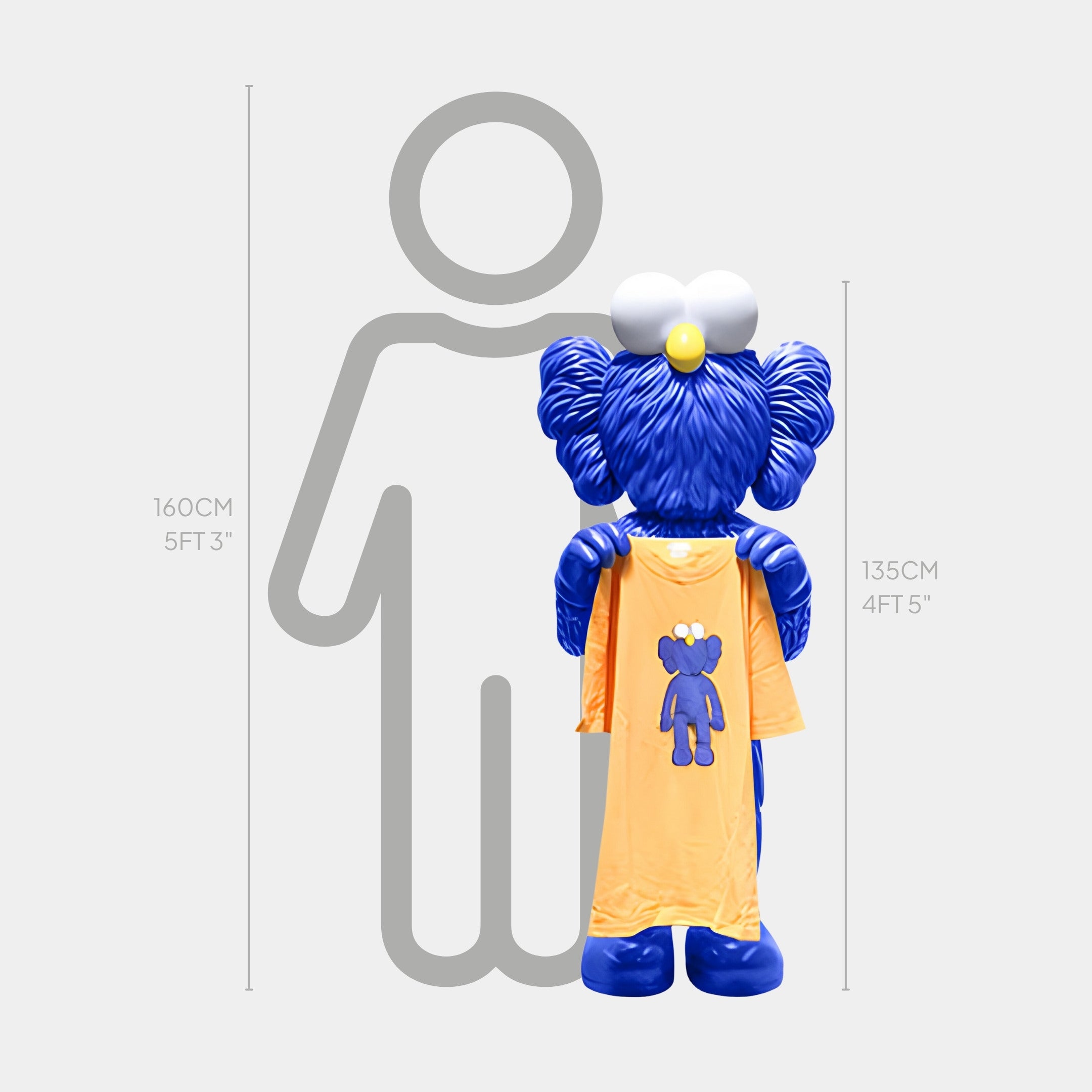 The Deep Blue Iconify Furry T-Shirt Sculpture by Giant Sculptures, featuring a large head and teddy bear yellow shirt, stands 135 cm (4 ft 5 in) tall beside a gray outline of a person measuring 160 cm (5 ft 3 in).