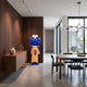 Deep Blue Iconify Furry T-Shirt Sculpture, 135cm, blue furry finish with yellow t-shirt, shown beside a wood-paneled wall in a dining area.