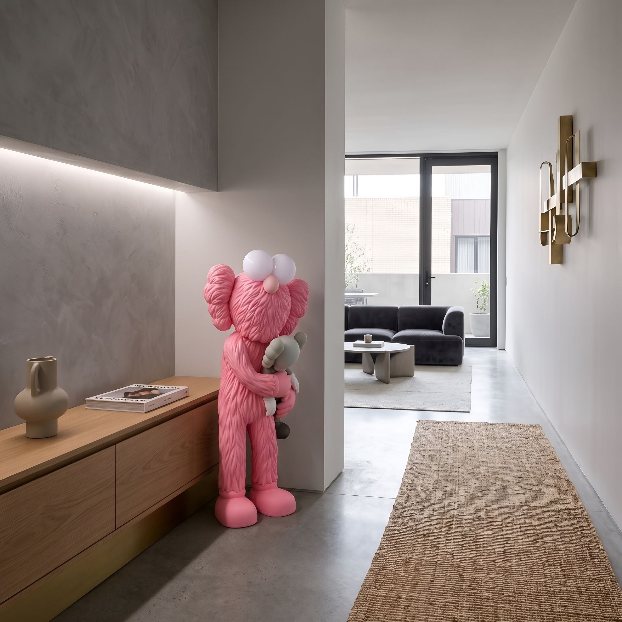 Petal Pink Iconify Loving Furry Sculpture, 135cm, pink figure embracing a grey companion, shown in a hallway near a wood console and dark sofa.
