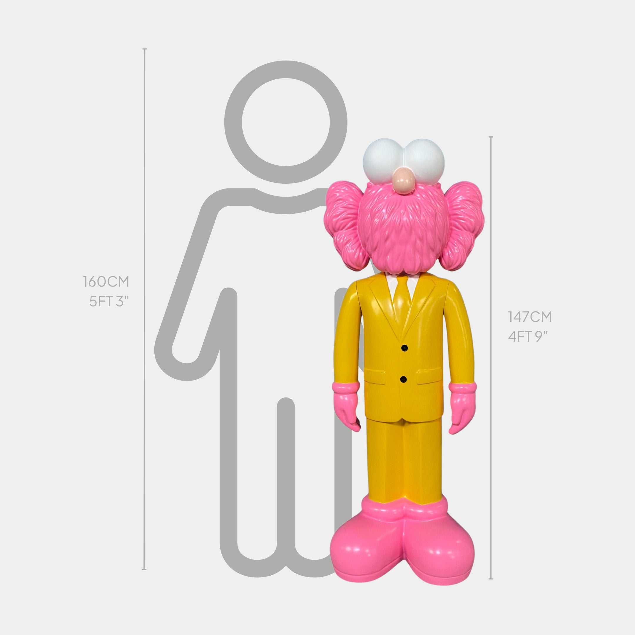 The Giant Sculptures Sunbeam Yellow Suit Iconify CEO Sculpture - 147cm, a pink cartoonish figure with big white eyes, stands before a height chart, appearing slightly shorter than a 160cm gray human silhouette.