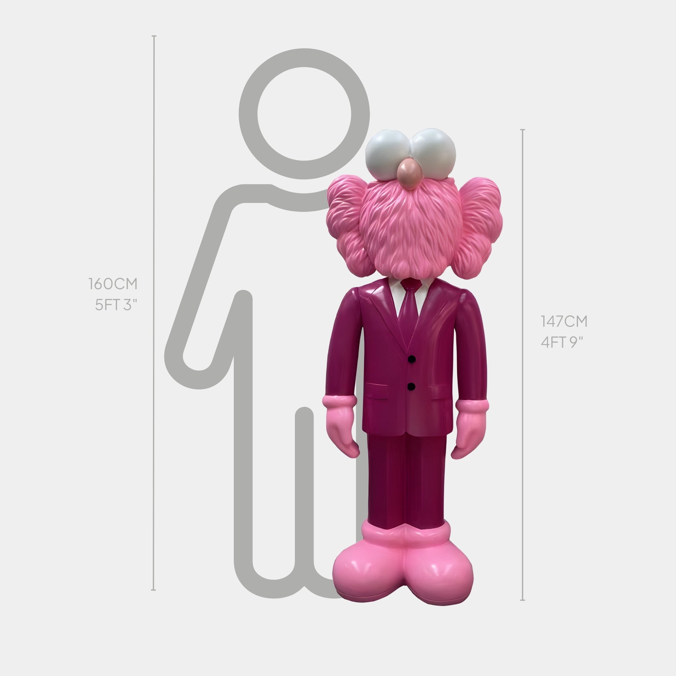 The Deep Magenta Suit Iconify CEO Sculpture by Giant Sculptures, standing at 147cm, features a pink cartoon character with large eyes and pink shoes. It exudes contemporary elegance in front of a height chart alongside a gray human outline, resembling a whimsical CEO.